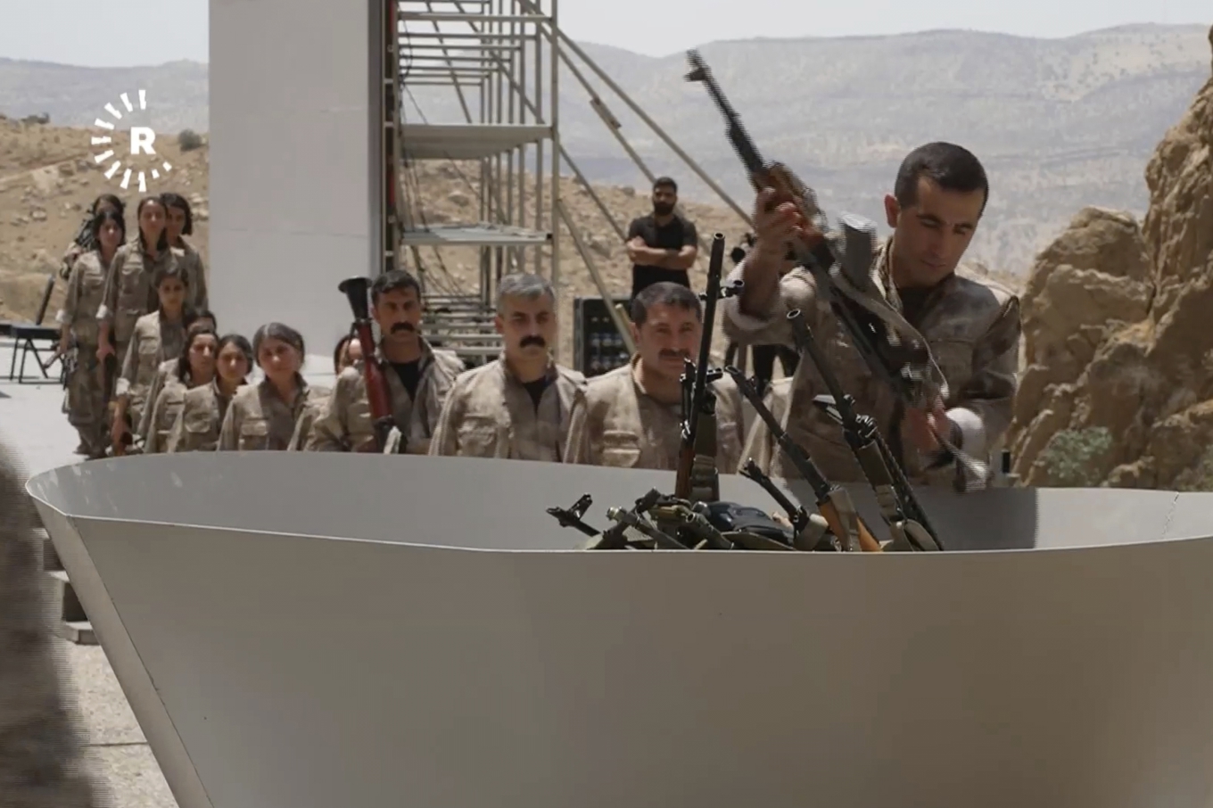 Bilden kommer från ett klipp som visar hur PKK i en symbolisk ceremoni bränner sina vapen. Foto: Rudaw TV via AP/TT