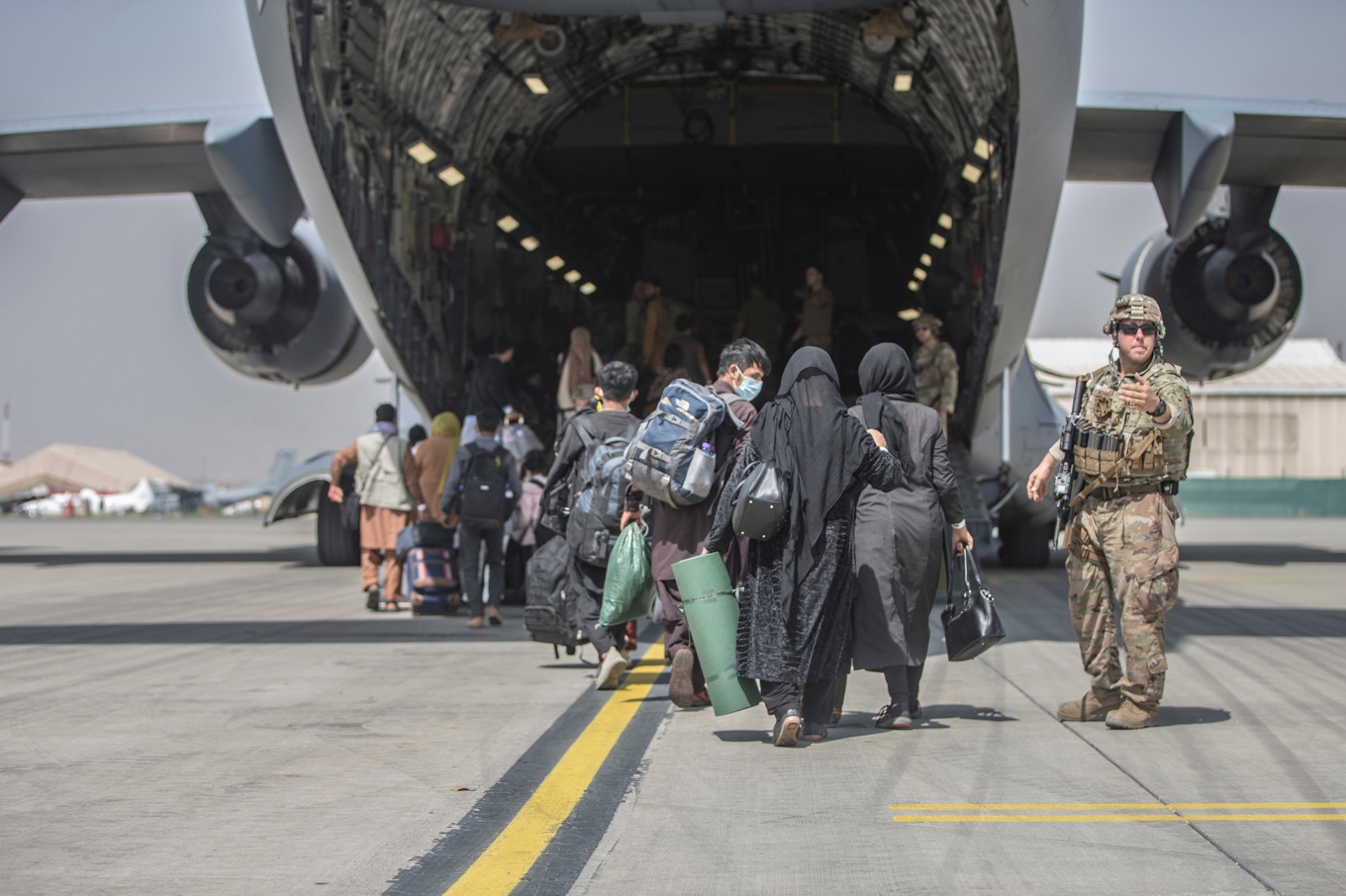 Familjer går ombord på ett amerikanskt militärflygplan i samband med evakueringen av Kabul efter talibanernas maktövertagande 2021. Foto: Samuel Ruiz/AP/TT