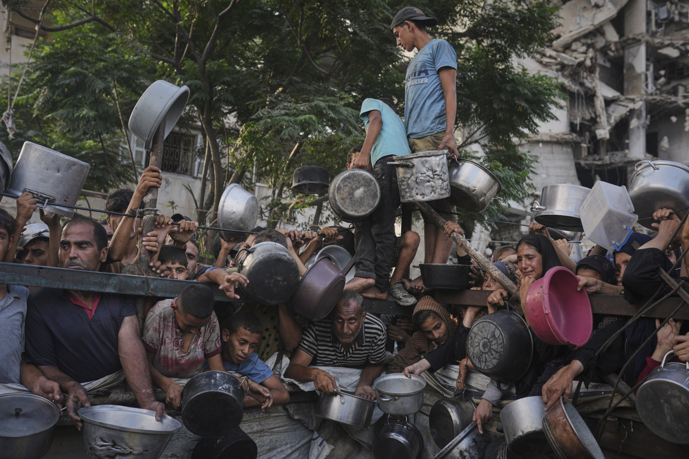 Palestinier försöker få ta del av mat vid en hjälpstation i Gaza stad i början av förra veckan. Foto: Jehad Alshrafi/AP/TT