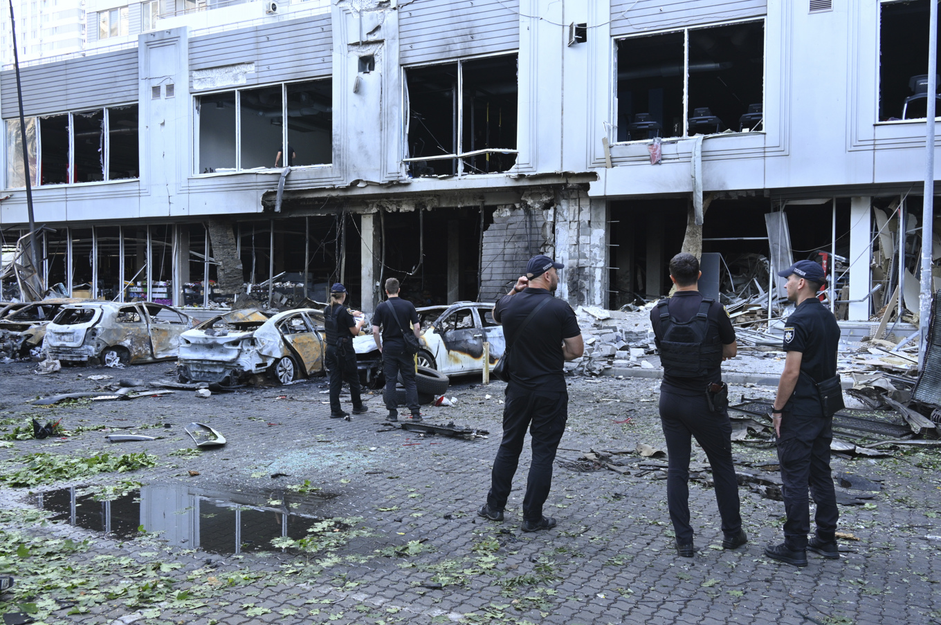 Poliser inspekterar förstörda bilar i ett bostadsområde i Odessa efter ryska drönarattacker mot staden natten till tisdagen. Foto: Michael Shtekel/AP/TT