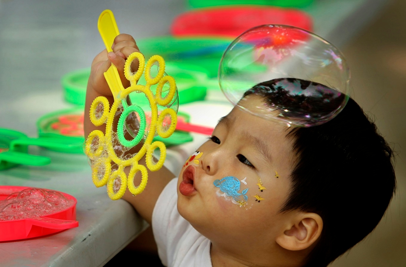 En pojke blåser såpbubblor i Sydkoreas huvudstad Seoul. Landet har världens lägsta födslotal. Arkivbild. Foto: Wally Santana/AP/TT