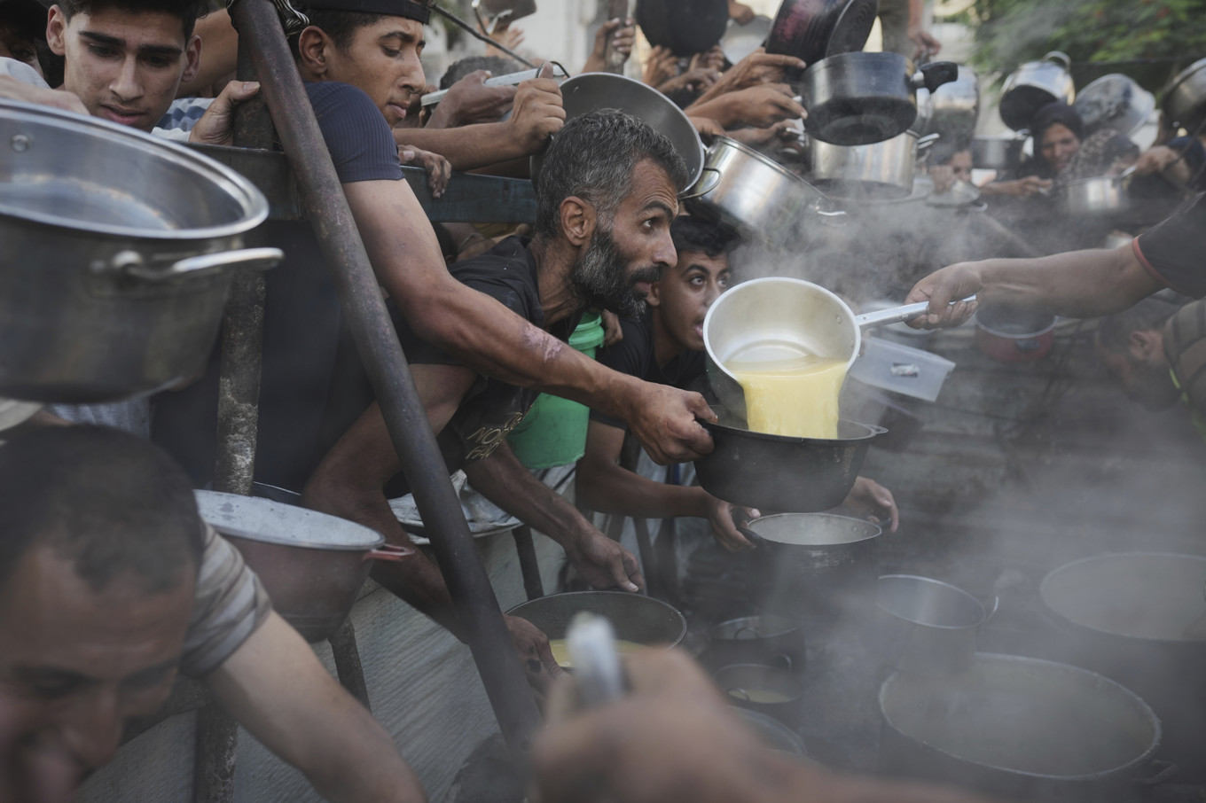 Palestinier vid en utdelningsplats för mat den 14 juli i år. Foto: Jehad Alshrafi/AP/TT