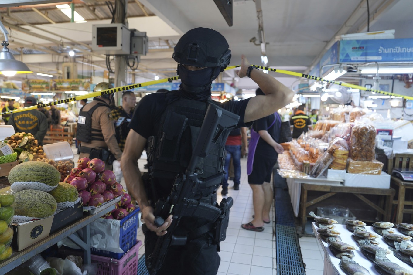 En polisman på plats på den populära matmarknaden Or Tor Kor där fem säkerhetsvakter sköts till döds på måndagen. Foto: Nava Sangthong/AP/TT