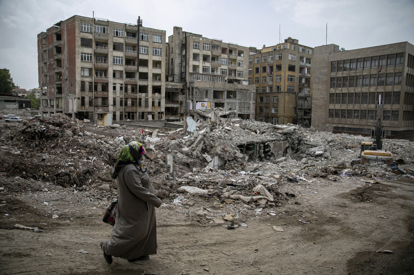 En kvinna passerar förstörda byggnader efter skalvet 2023. Foto: Metin Yoksu/AP/TT