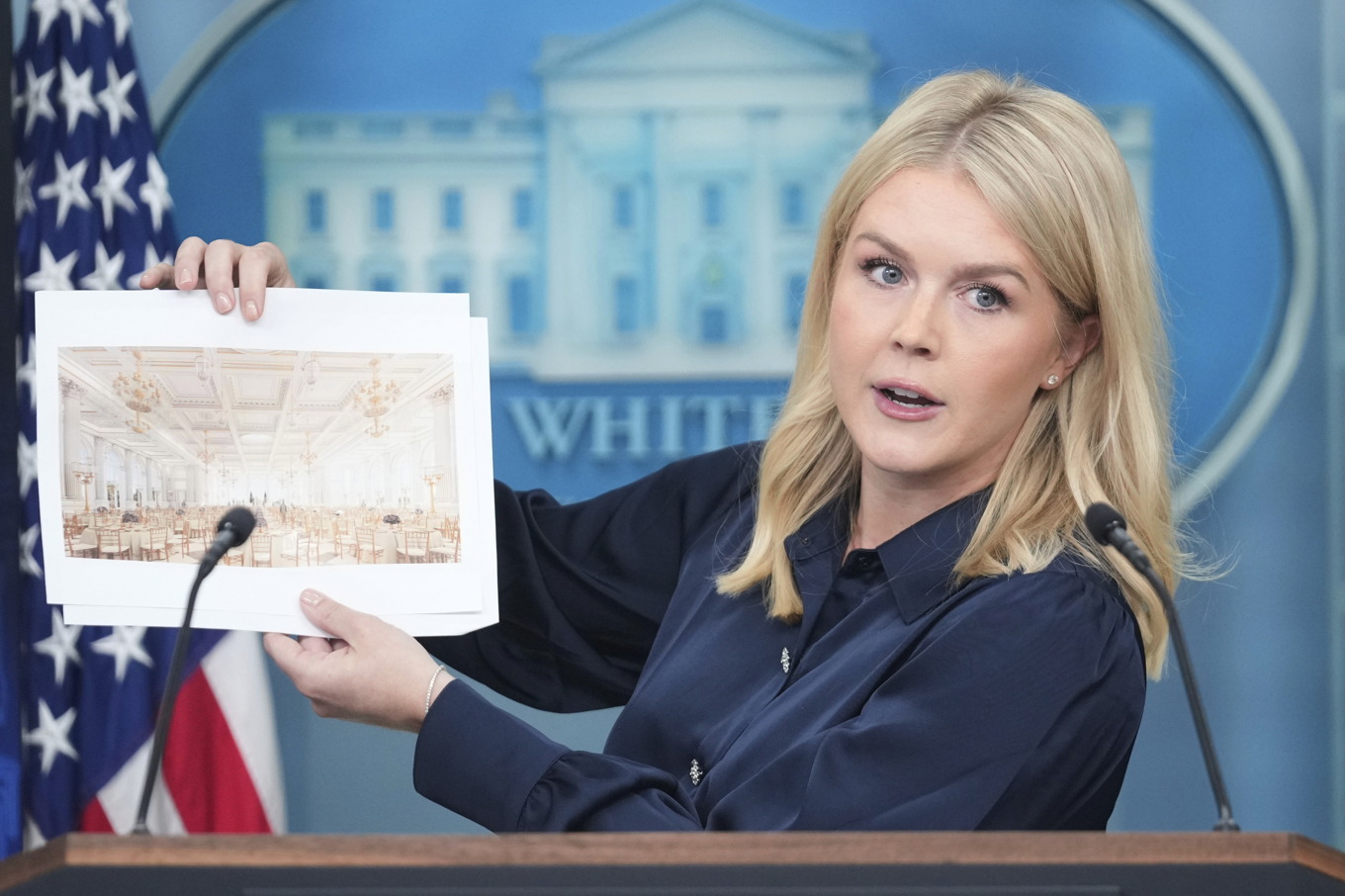 Vita husets pressekreterare Karoline Leavitt visar upp fotografier av den nya festsalen som ska byggas. Foto: Mark Schiefelbein/AP/TT