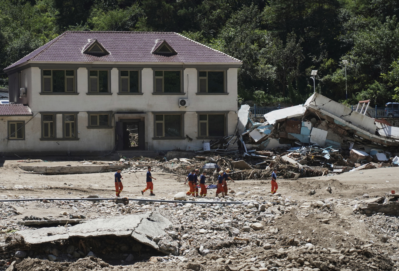 Räddningspersonal evakuerar en strandad invånare i utkanten av Peking efter förra veckans regnoväder. Bild från i onsdags. Foto: Zhang Chenlin/AP/TT