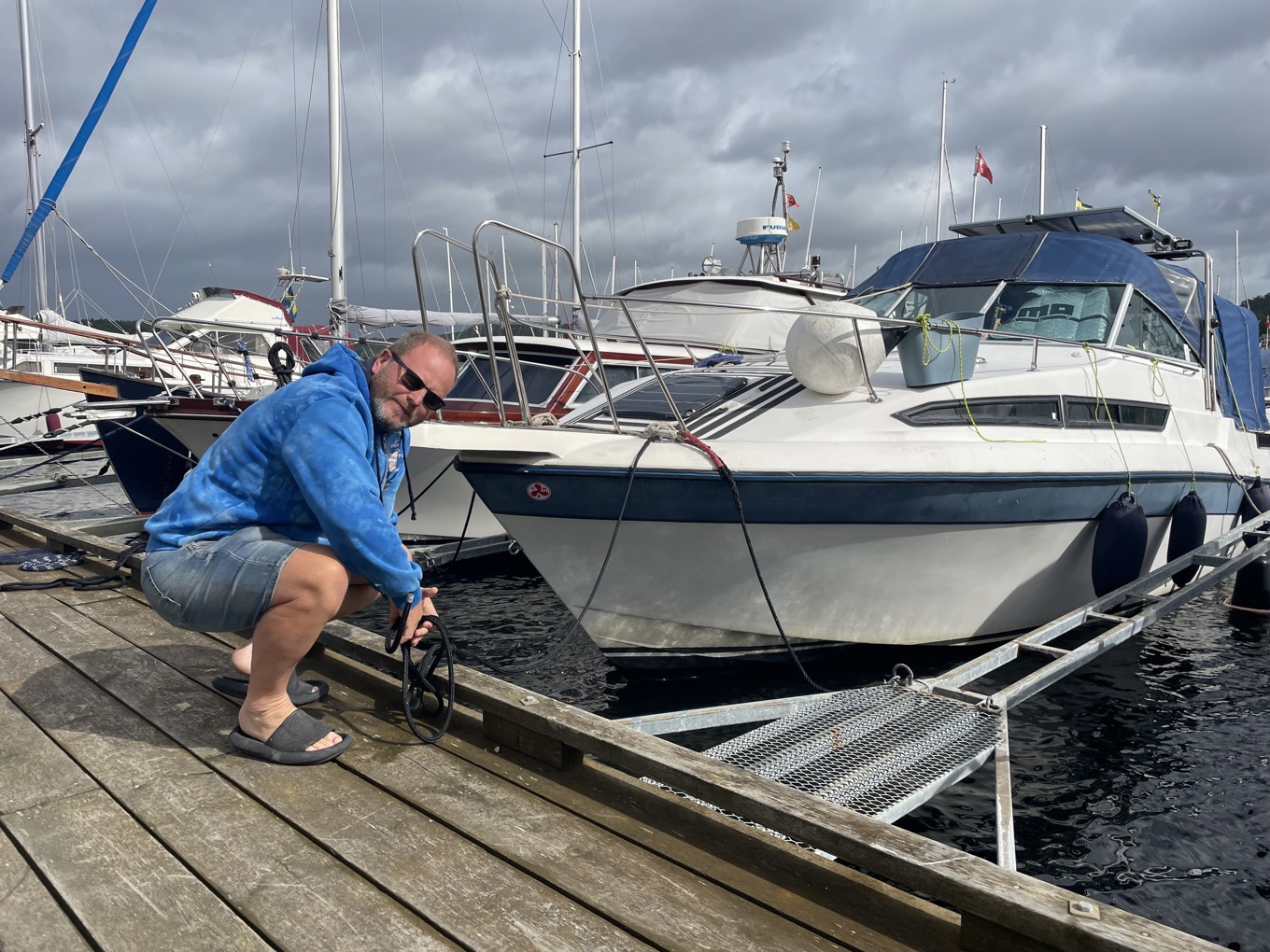 Johnny Dauksz kontrollerade på tisdagsmorgonen förtöjningarna på sin båt i hamnen i Ljungskile. Eftersom vattennivån kan stiga under vindarnas framfart är det viktigt att justera tamparna. Foto: Ellen Ahinko Andersson/TT