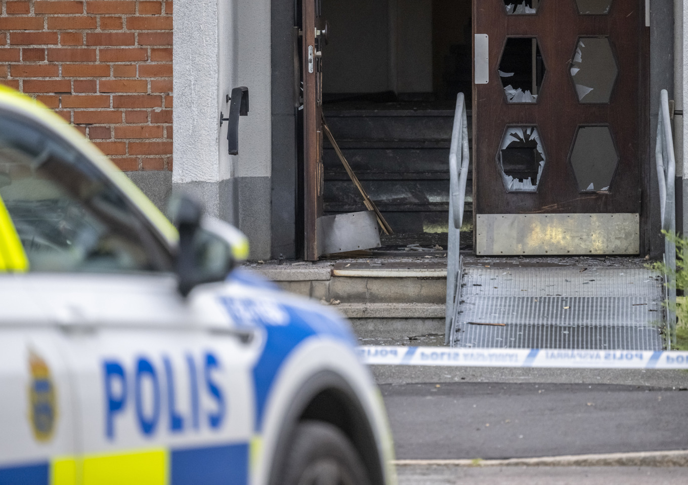 Polis på plats och skador efter en detonation i en entré till ett flerfamiljshus på Västra Storgatan i Kristianstad tidigt på torsdagsmorgonen. Foto: Johan Nilsson/TT
