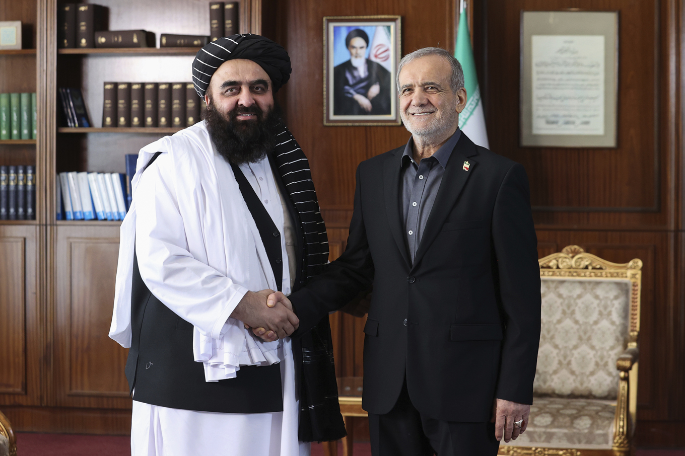 Afghanistans utrikesminister Amir Khan Muttaqi skakar hand med Irans president Masoud Pezeshkian under ett möte i Teheran i maj i år. Foto: Iranska presidentkansliet via AP/TT