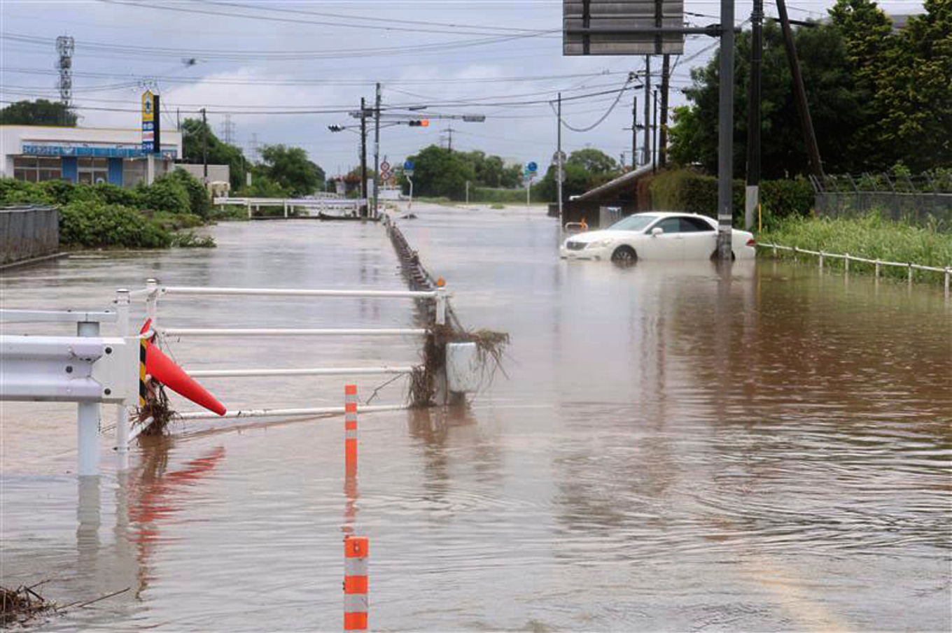 Vägar är översvämade till följd av omfattande regn i Kumamoto i södra Japan under måndagen. Foto: Kyodo News/AP/TT