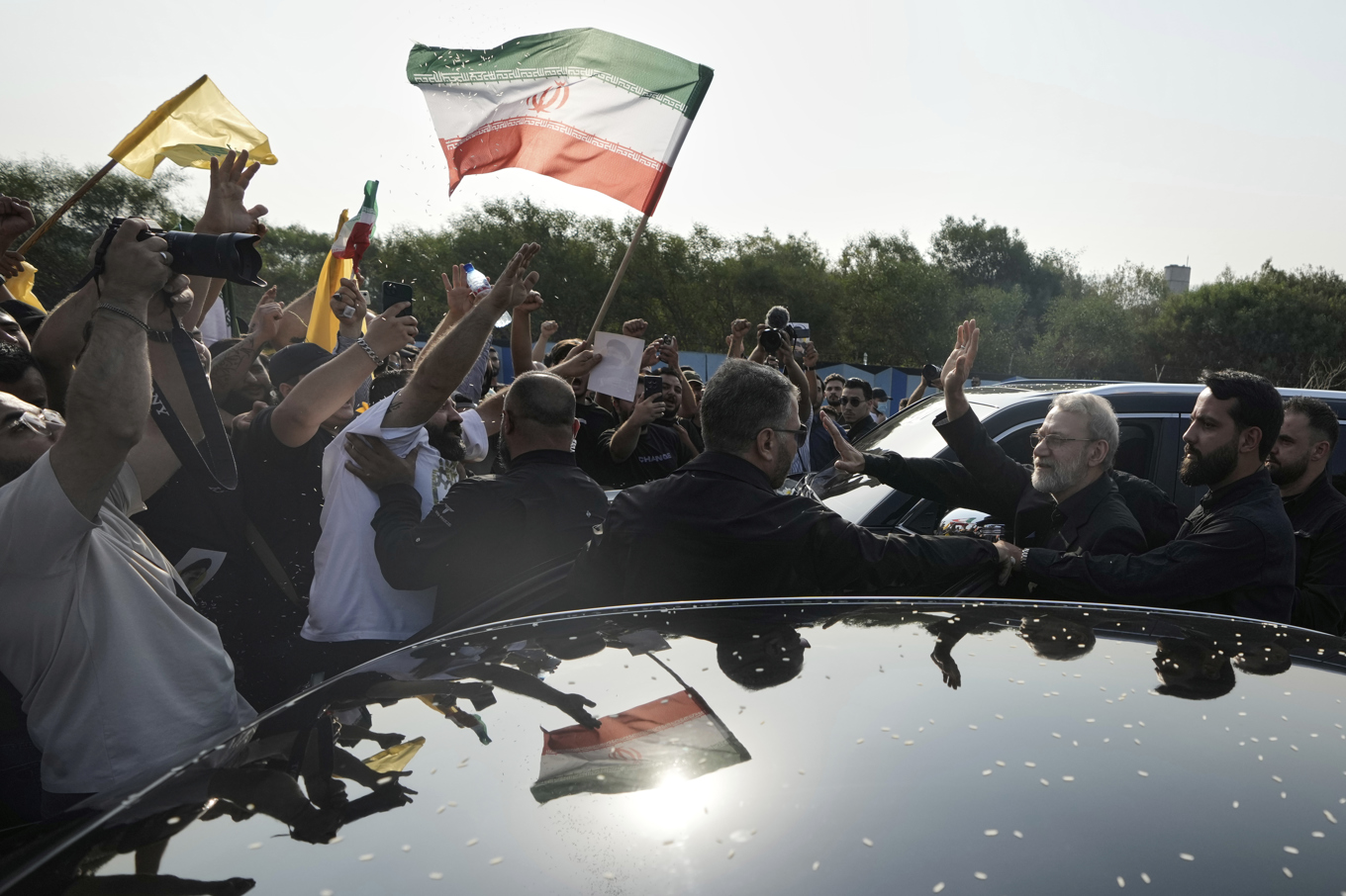 Irans säkerhetschef Ali Larijani, till höger, vinkar mot Hizbollahanhängare vid flytplatsen i Beirut. Foto: Bilal Hussein/AP/TT