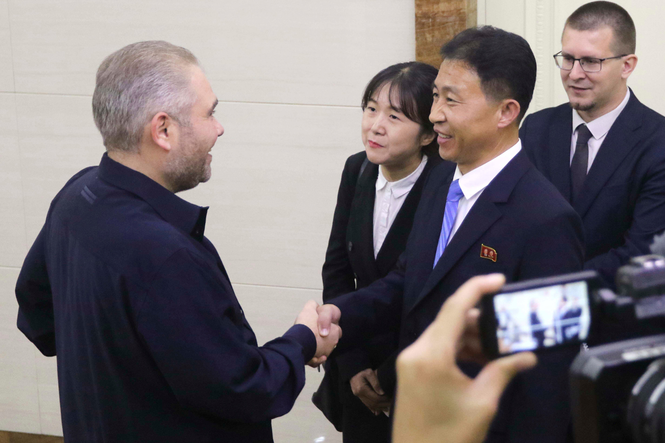 Rysslands vice kulturminister Andrej Maluisjev välkomnas av nordkoreanska politiker i Pyongyang. Foto: Cha Song Ho/AP/TT