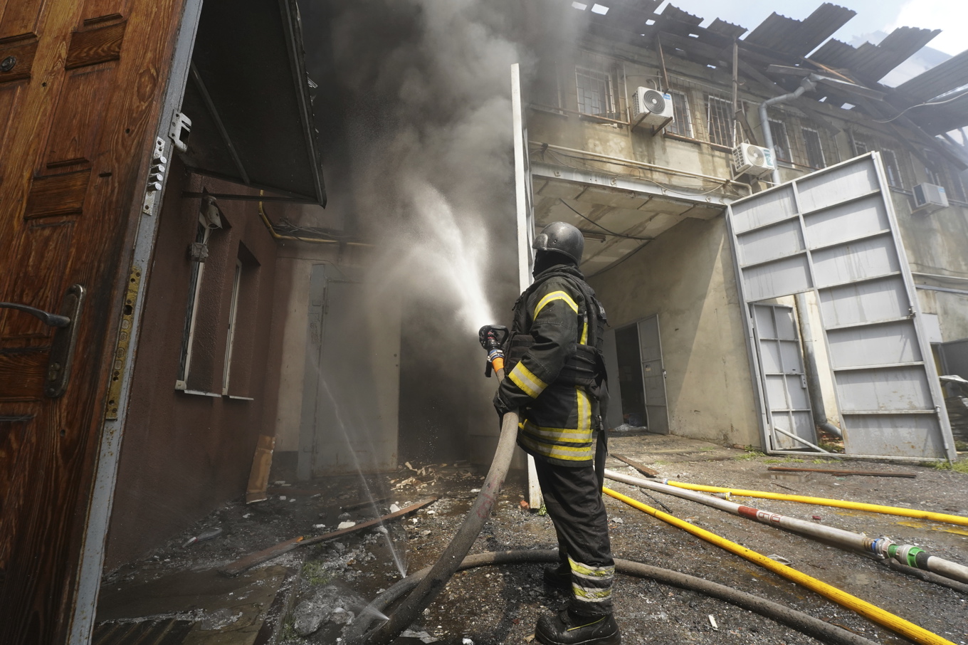 Räddningspersonal släcker en eld efter en rysk attack mot ett bostadsområde i Charkiv i Ukraina. Foto: Andrii Marienko/AP/TT
