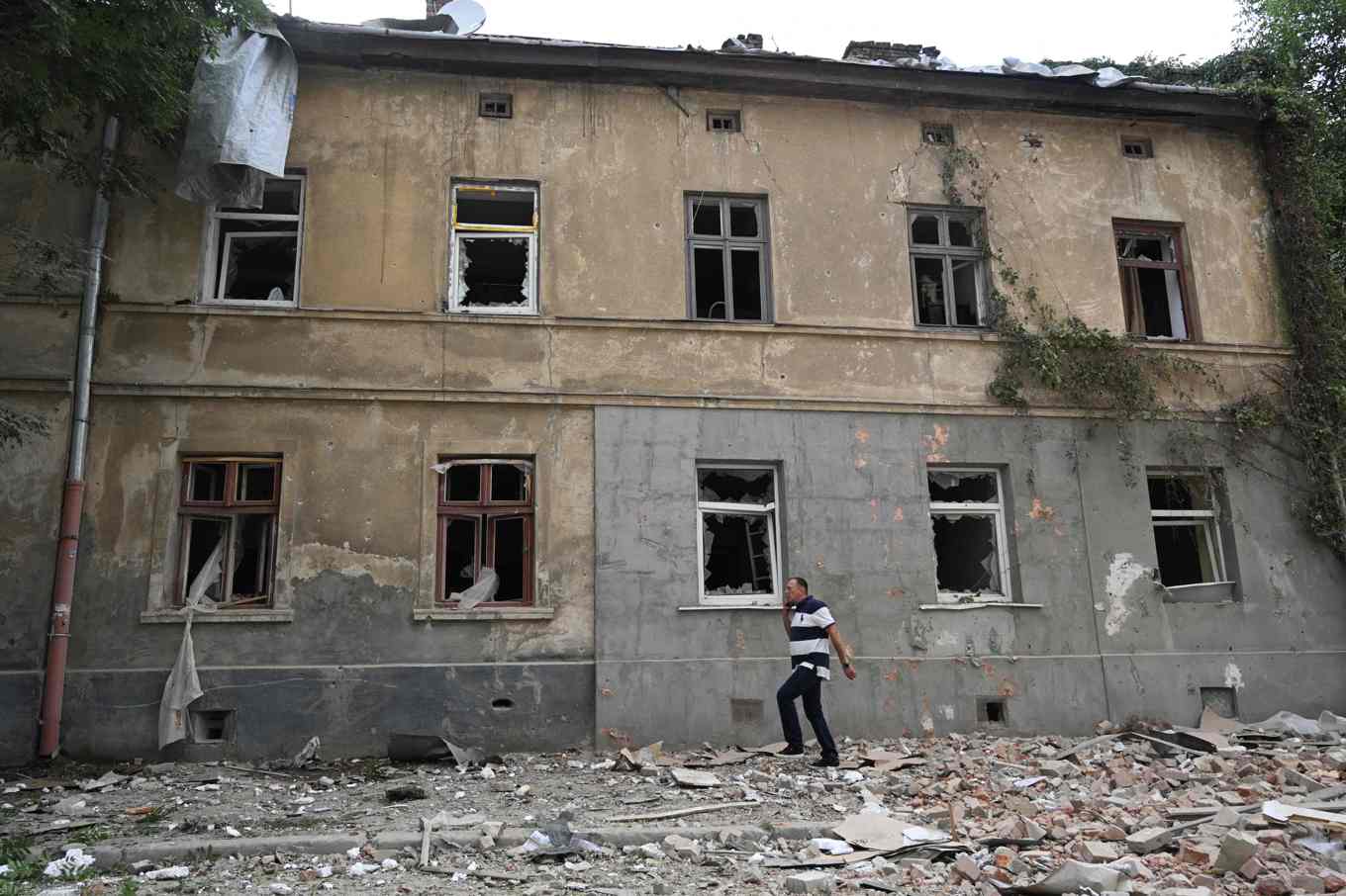 En man går förbi ett bostadshus i Lviv som skadats i nattens ryska attacker. Foto: Yuriy Dyachyshyn/AFP/TT