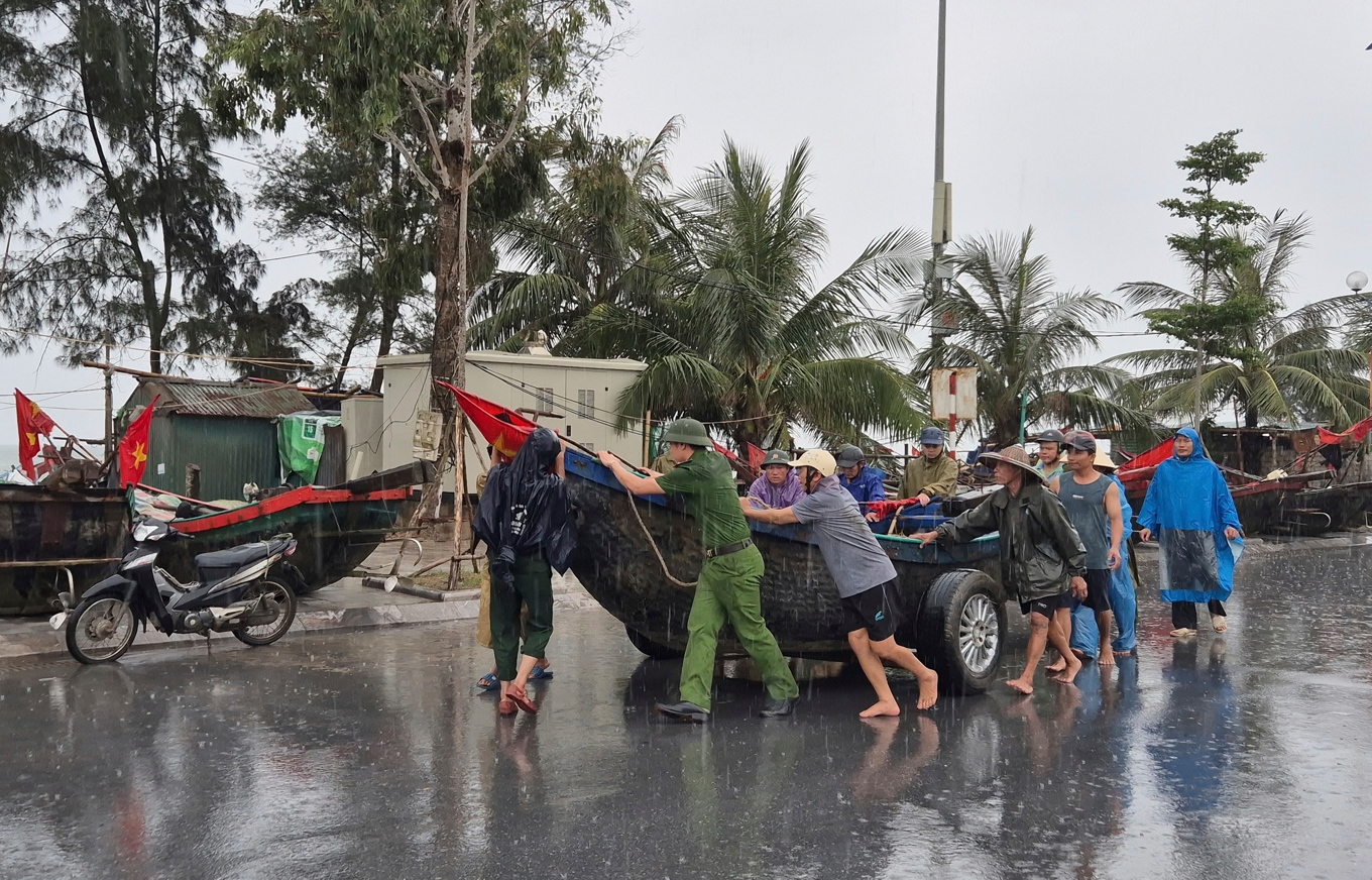 Människor flyttar en båt från en strand inför en tidigare tyfon som drog in över Vietnam i juli. Foto: Le Hoang/AP/TT