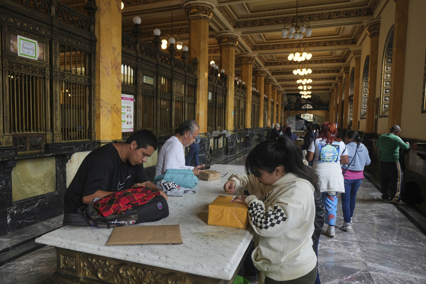 Människor förbereder paket som ska postas vid ett postkontor i Mexico City på onsdagen. Foto: Fernando Llano/AP/TT