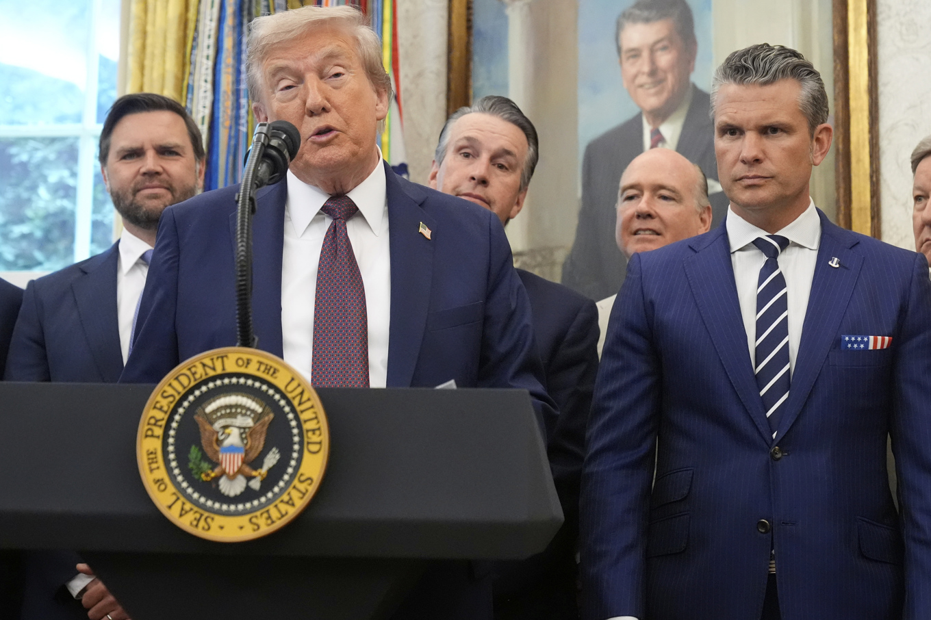President Donald Trump i Vita huset, efter att inte ha synts till på en vecka. Vicepresident J D Vance och försvarsminister Pete Hegseth bakom honom. Foto: Mark Schiefelbein/AP/TT