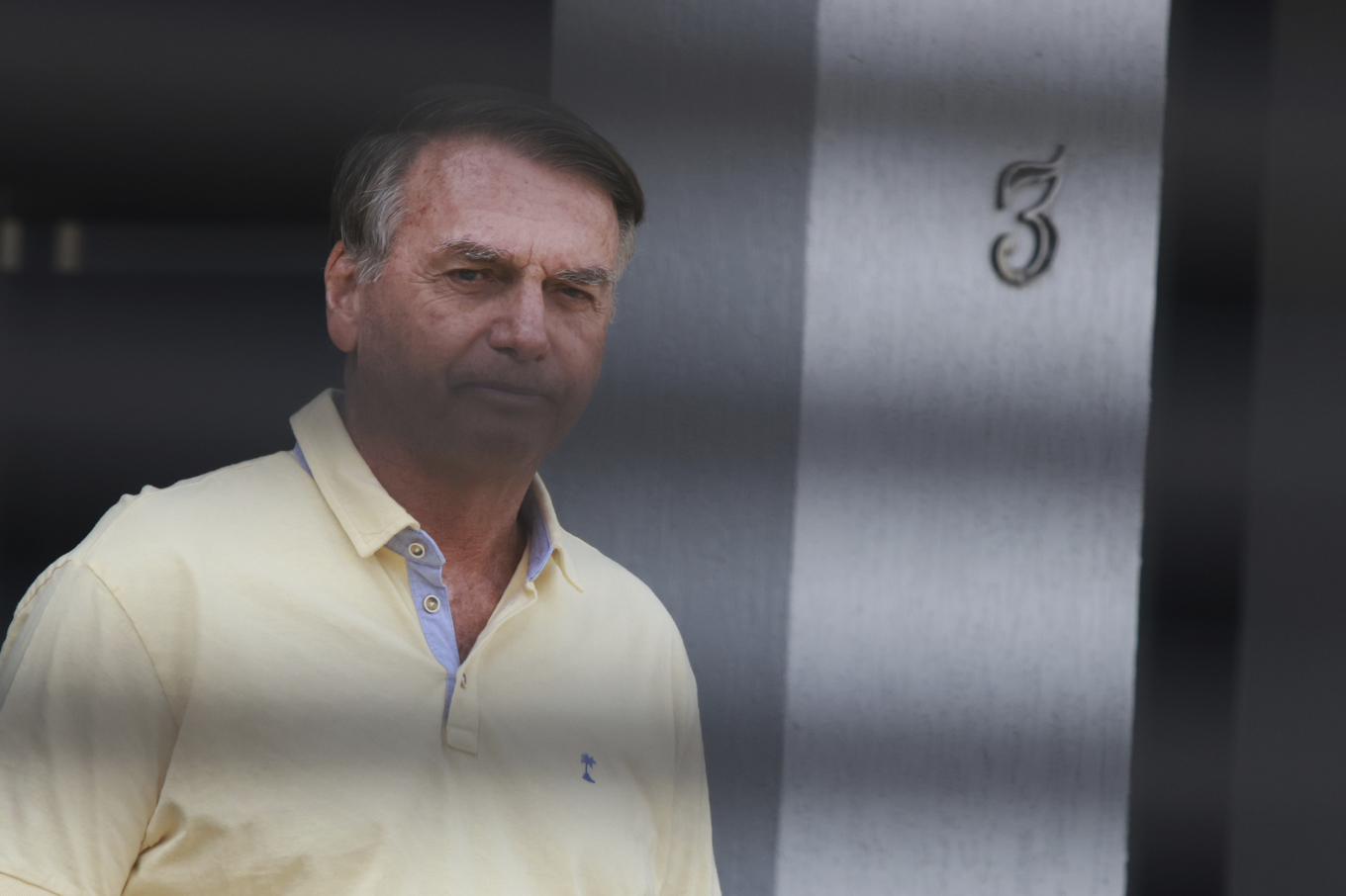 Jair Bolsonaro står vid sitt hem, där han befinner sig under husarrest i väntan på dom. Bilden är tagen 3 september. Foto: Luis Nova/AP/TT