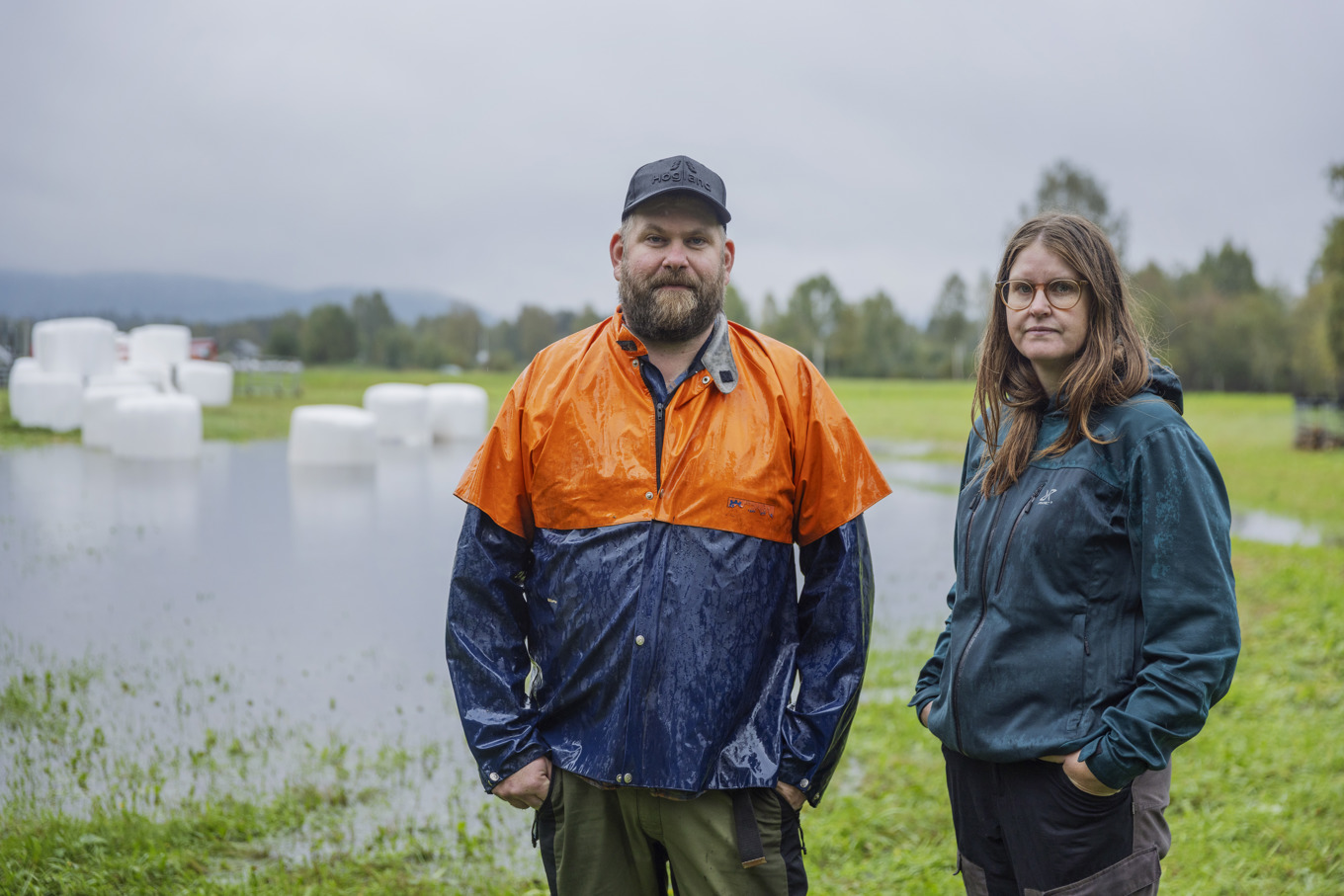 Björn och Elin Mårtensson i Kubbe framför de flytande ensilagebalarna som fick fångas in hastigt när vattnet steg. Foto: Caisa Rasmussen/TT