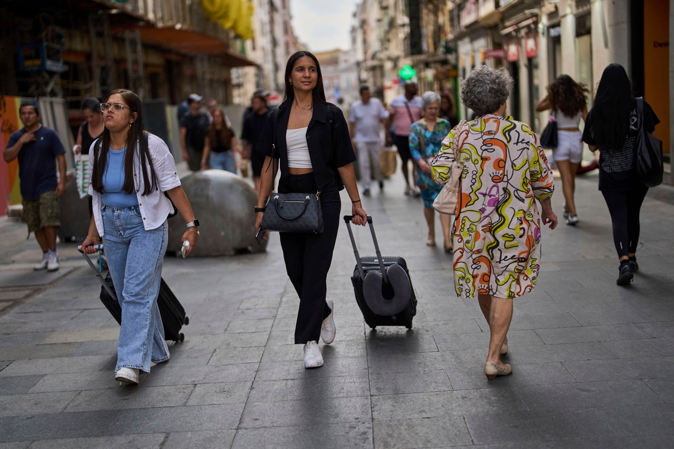 FILE - Tourists carry their luggage in downtown Madrid, Spain, June 3, 2025. (AP Photo/Manu Fernandez, File) RPSN101 Foto: Manu Fernandez/AP