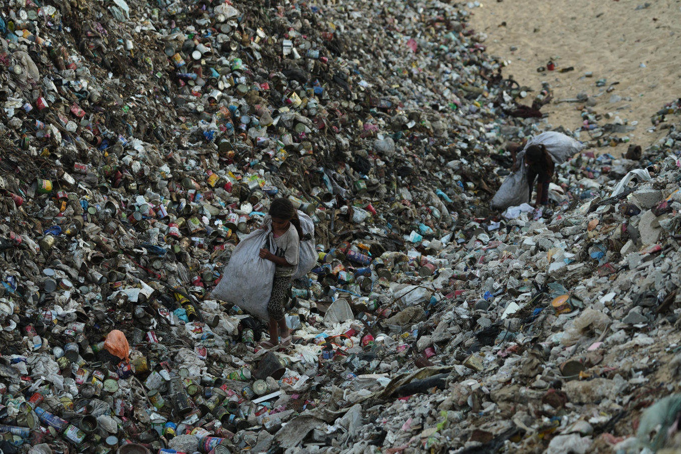 Barn i Khan Yunis i Gaza samlar sopor. Foto: Jehad Alshrafi/AP/TT