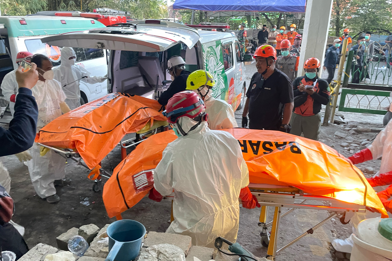 Räddningsarbetare transporterar avlidna efter att en skolbyggnad i Sidoarjo, nära Surabaya på östra Java i Indonesien, rasat. Bild från i fredags. Foto: Trisnadi/AP/TT