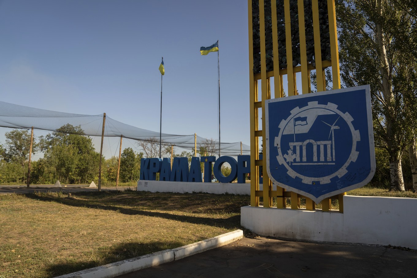 Skyltar vid infarten till Kramatorsk. Över vägen sitter nät som ska skydda bilar mot drönare. Bild från i september. Foto: Aleks Babenko/AP/TT