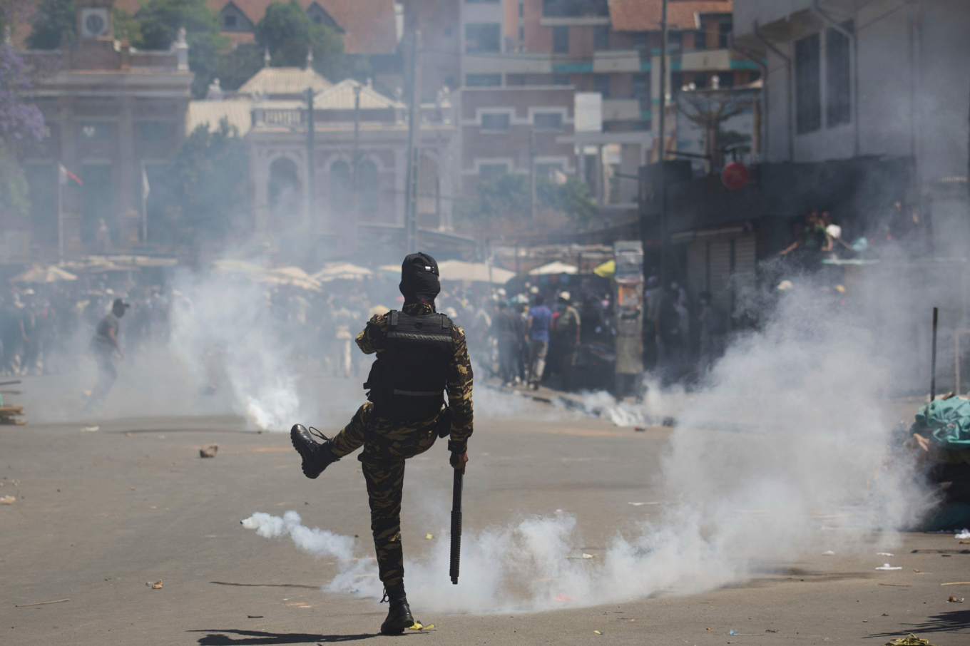 En polis sparkar en tårgasgranat i Antananarivo under protester i torsdags. Foto: Alexander Joe/AP/TT