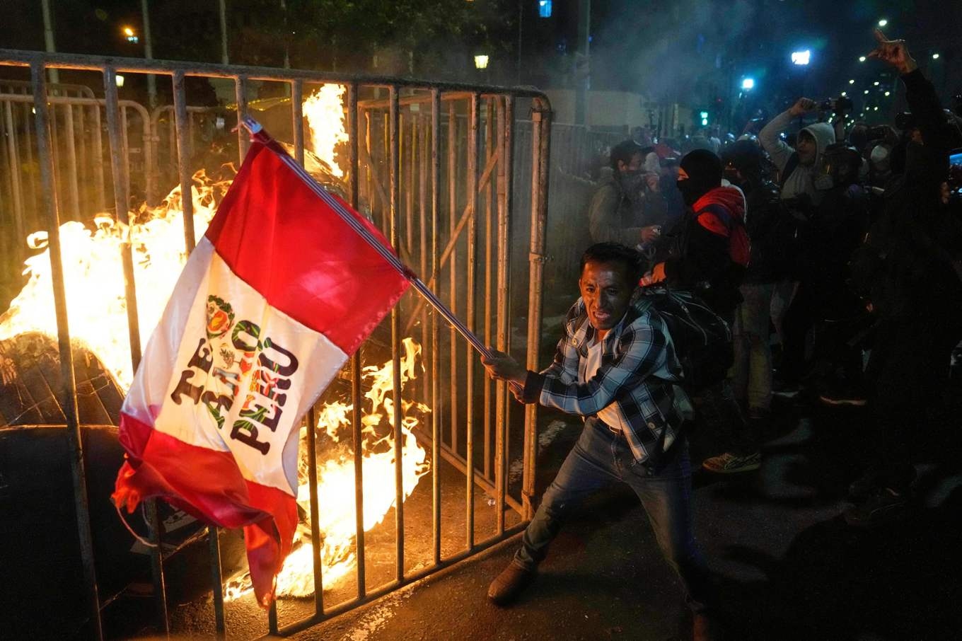 En demonstrant med den peruanska flaggan i Lima i onsdags. Foto: Martin Mejia/AP/TT