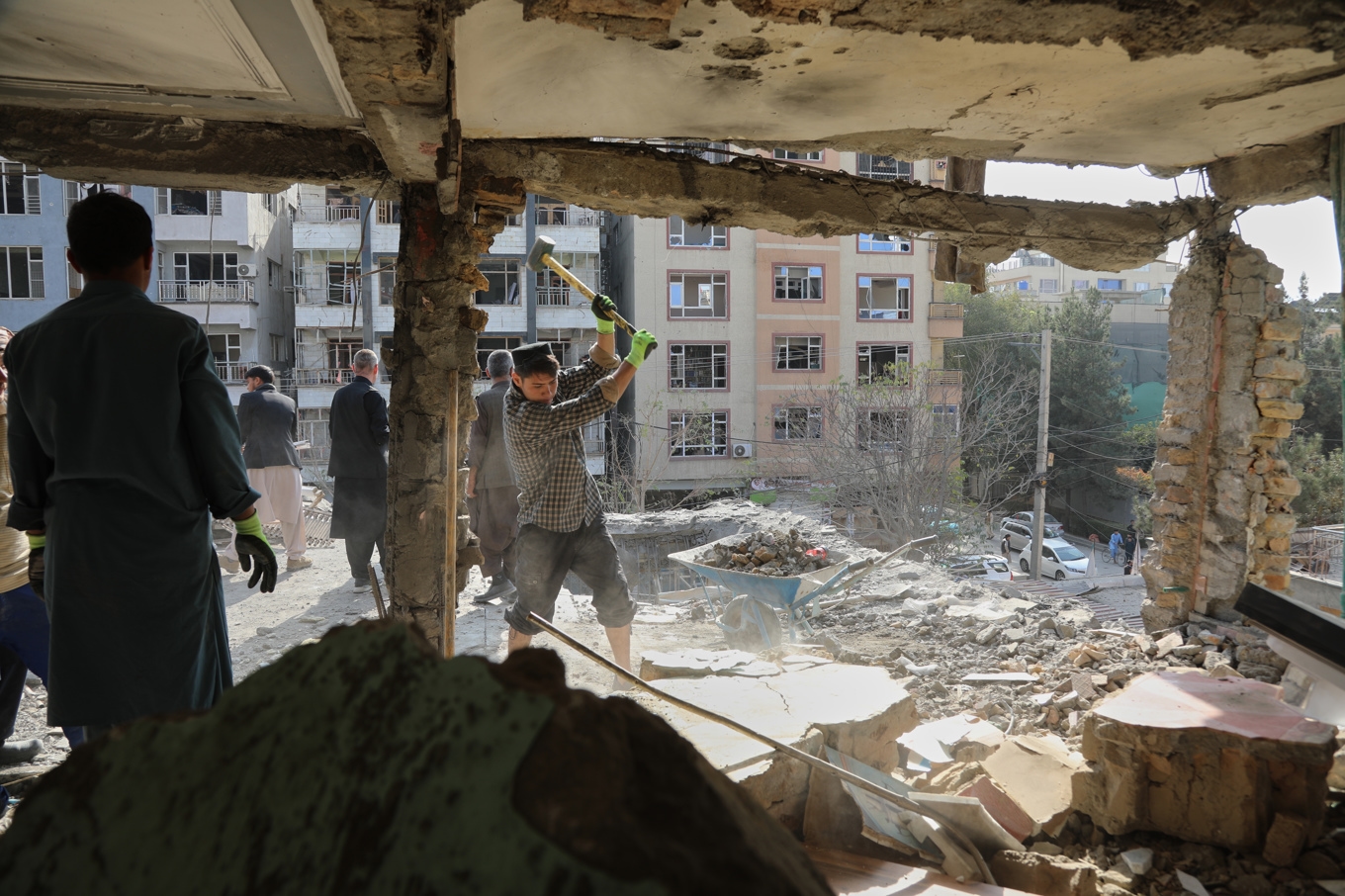 Boende röjer upp i rasmassorna efter en drönarattack som tillskrivs Pakistan i Afghanistans huvudstad Kabul under onsdagen. Foto: Siddiqullah Alizai/AP/TT