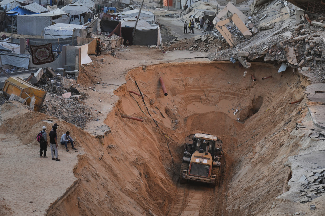 Palestinier ser på när Hamasmedlemmar letar efter kvarlevor från gisslan i Khan Yunis på södra Gazaremsan. Bilden är tagen 18 september. Foto: Jehad Alshrafi/AP/TT
