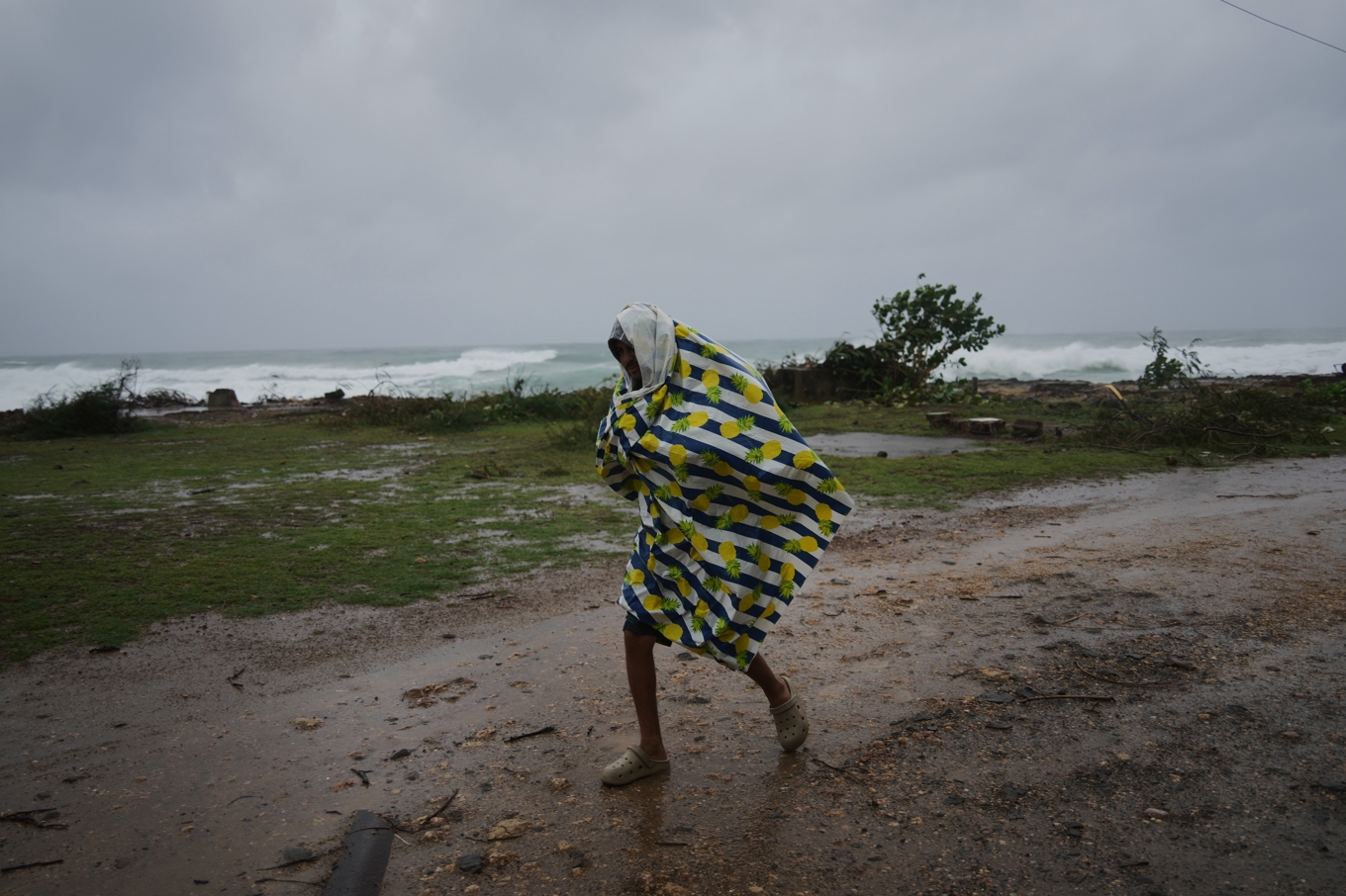 En man tar sig fram i regnet inför orkanen Melissas ankomst i Cañizo i Santiago de Cuba på tisdagen lokal tid. Foto: Ramon Espinosa/AP/TT