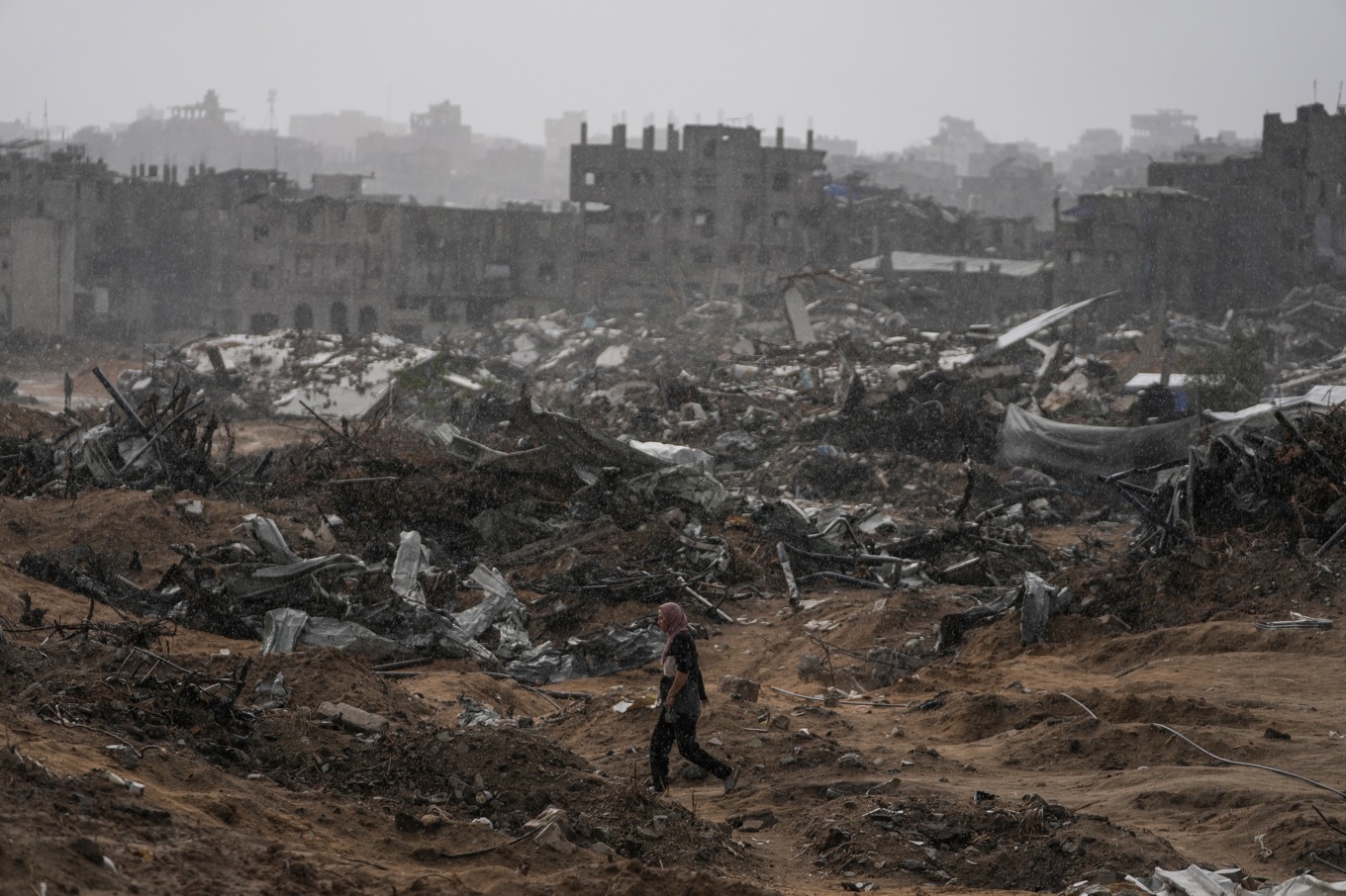 En palestinsk kvinna promenerar bland ruinerna i ett tidigare bostadskvarter i staden Gaza. Bilden togs den 14 november. Foto: Jehad Alshrafi/AP/TT
