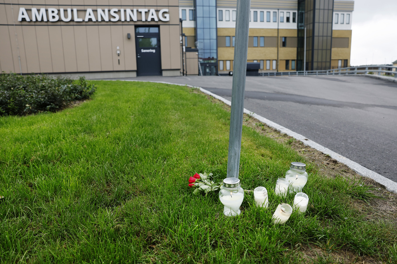 Blommor och ljus utanför ambulanssjukvården i Region Gävleborg i Hudiksvall, dagen efter att en ambulanssjukvårdare blivit dödad i tjänsten i Harmånger Nordanstig kommun. Foto: Mats Andersson/TT
