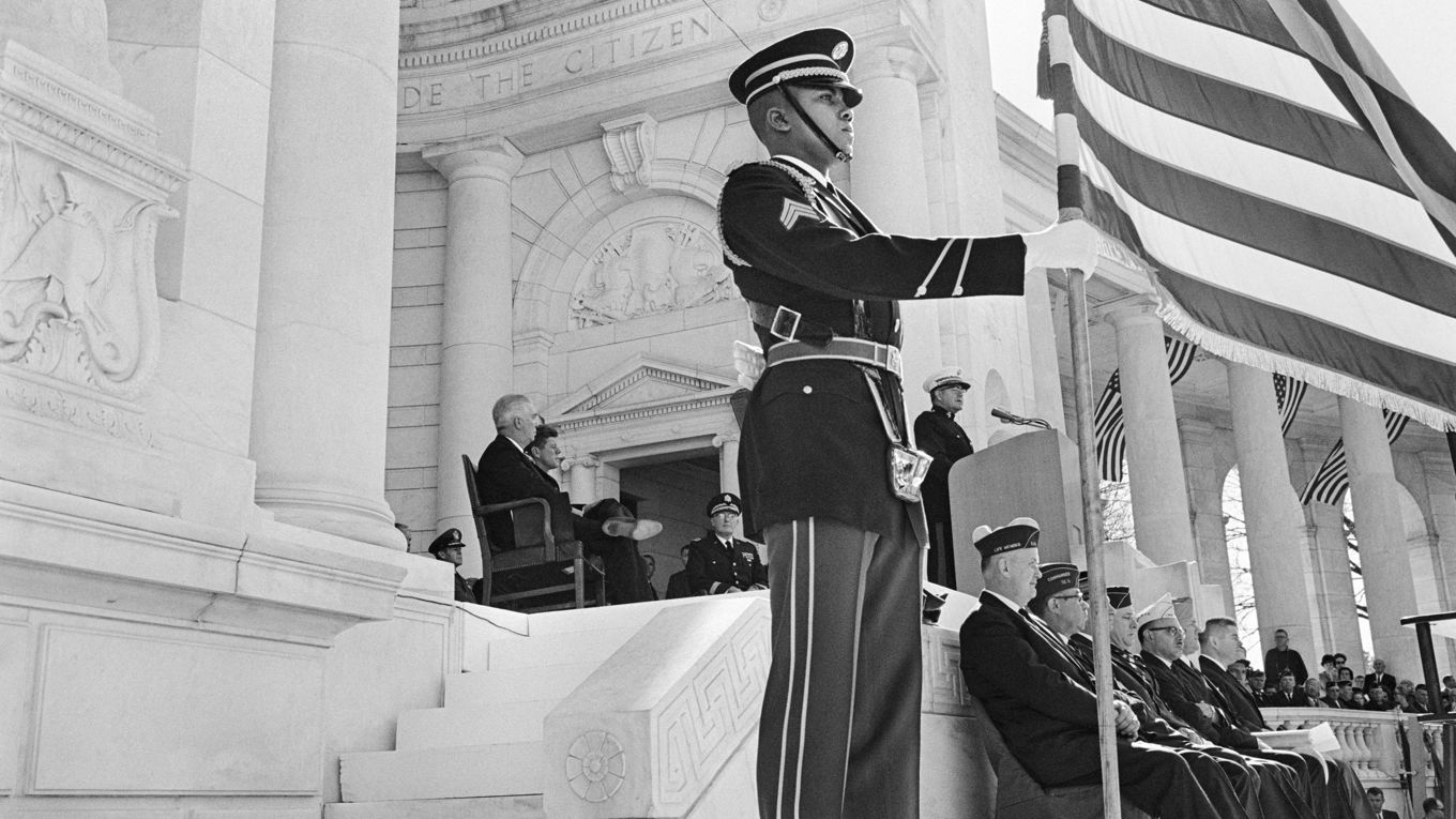 USA:s president John F. Kennedy sitter på denna bild i amfiteatern vid Arlingtonkyrkogården under Veterans Day-högtiden den 11 november 1963. Mindre än två veckor senare, den 25 november, begravdes han på samma kyrkogård. Foto: AFP via Getty Images