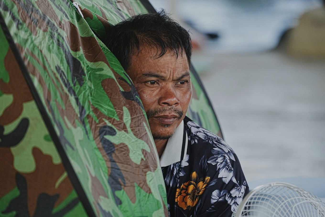 En man som tvingats fly sitt hem på grund av striderna sitter i ett tält i den kambodjanska provinsen Banteay Meanchey på lördagen. Foto: Heng Sinith/AP/TT