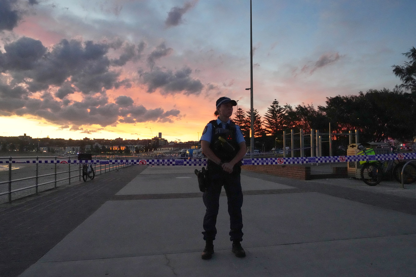 En polis bevakar avspärrningar vid Bondi Beach i Sydney. Foto: Mark Baker/AP/TT