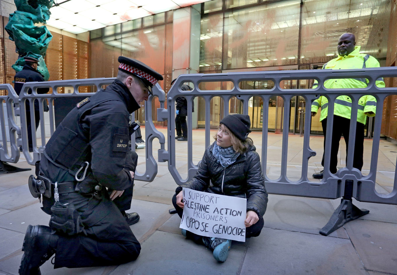 Greta Thunberg under demonstrationen där hon syns hålla upp ett plakat med texten ”Jag stödjer fångarna från Palestine Action. Jag är emot folkmord”. Foto: Prisoners for Palestine/AP/TT