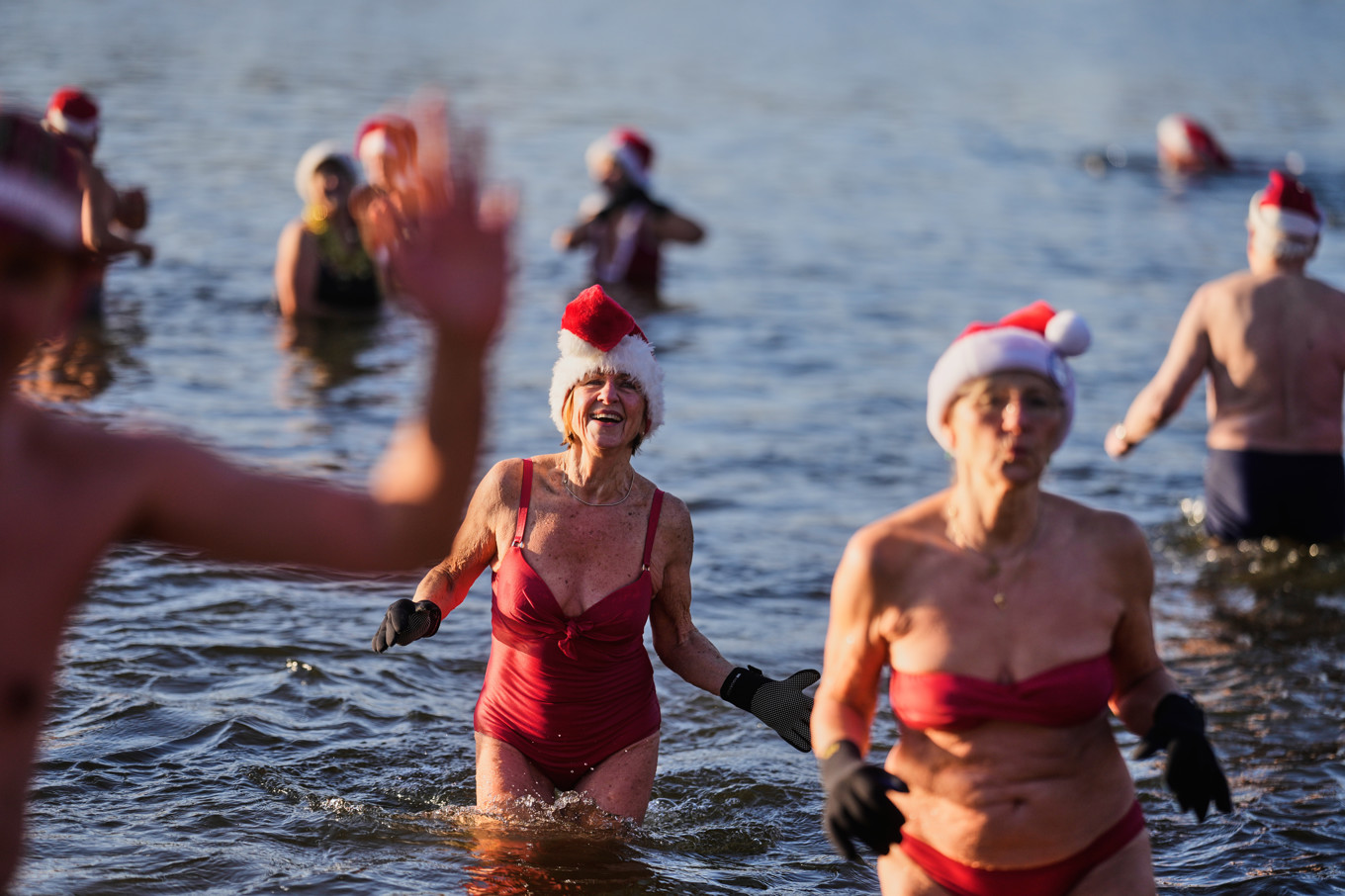 Medlemmar i vinterbadarklubben Berliner Seehunde tar ett dopp i sjön Orankesee utanför Berlin. Foto: Markus Schreiber/AP/TT