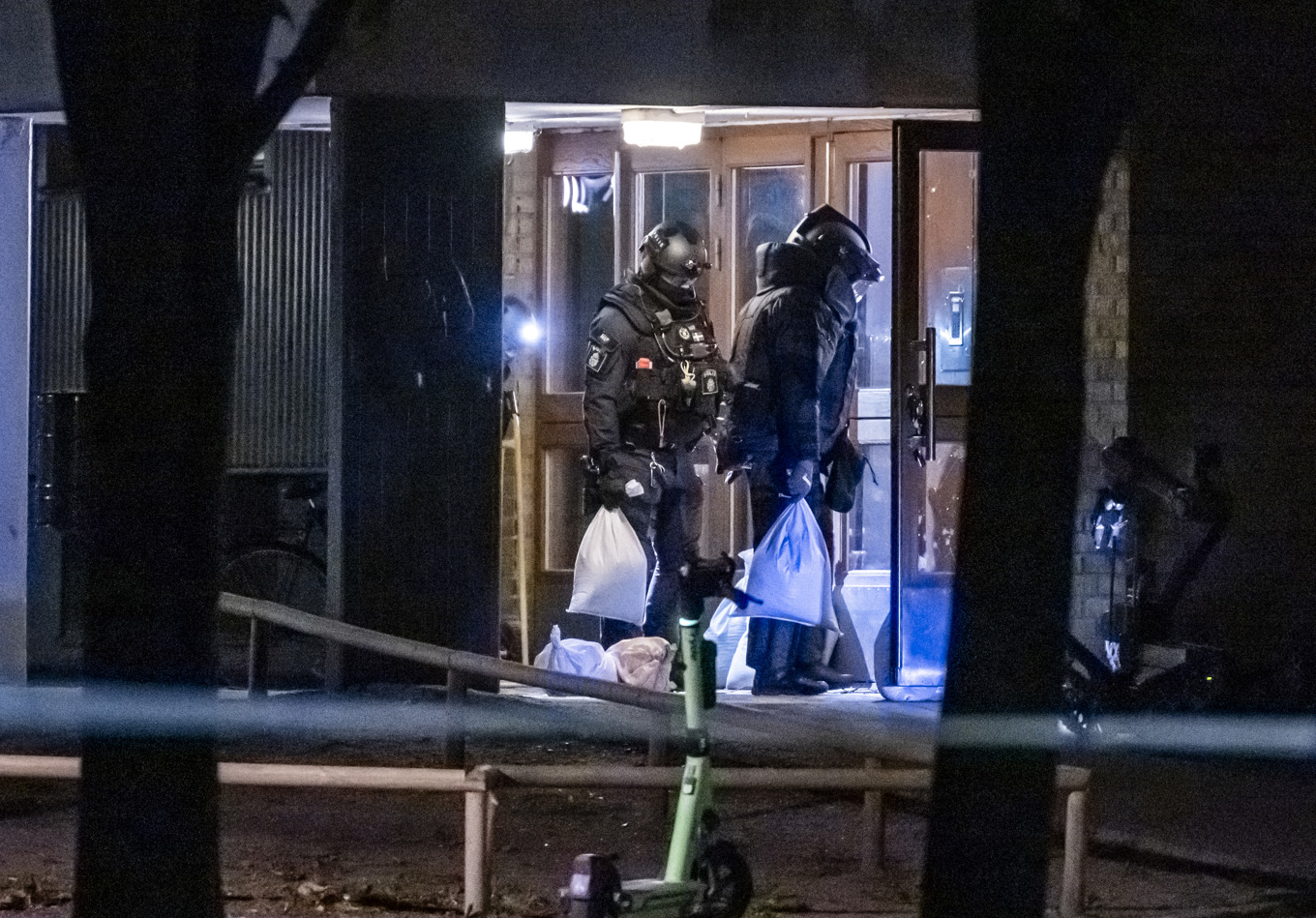 Polisens bombtekniker på plats i skyddsdräkt och med sandsäckar för att oskadliggöra flera handgranater i trapphuset på ett flerfamiljshus i Malmö i september i år. Arkivbild. Foto: Johan Nilsson / TT