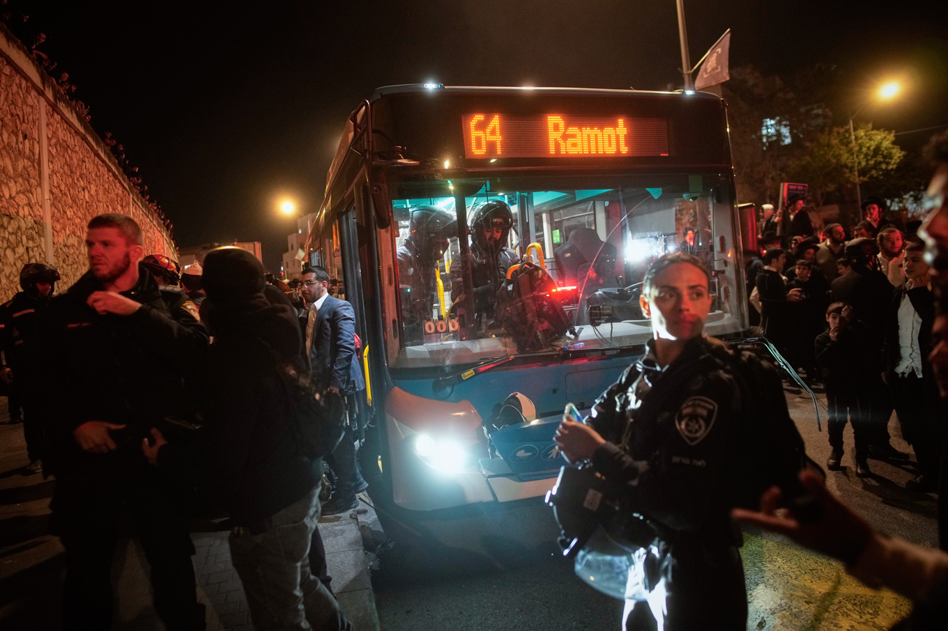Israelisk polis undersöker en buss som kört på demonstranter i Jerusalem. Foto: Ohad Zwigenberg/AP/TT