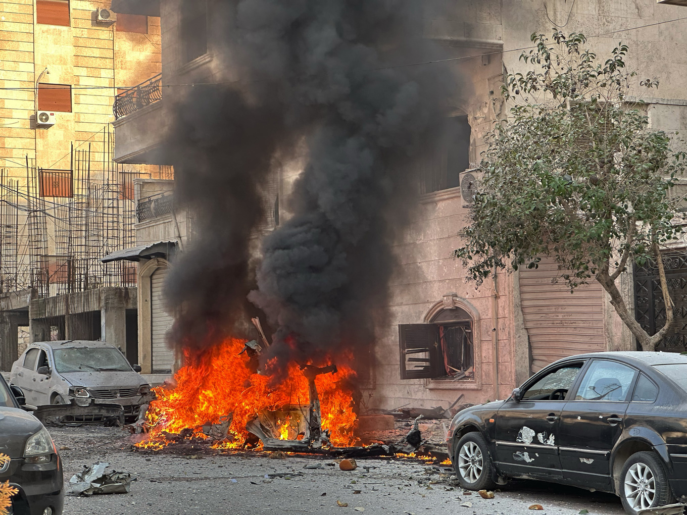 En bil i brand under sammandrabbningarna mellan kurdiska styrkor och den reguljära armén i Aleppo. Bild från onsdagen. Foto: Omar Albam/AP/TT