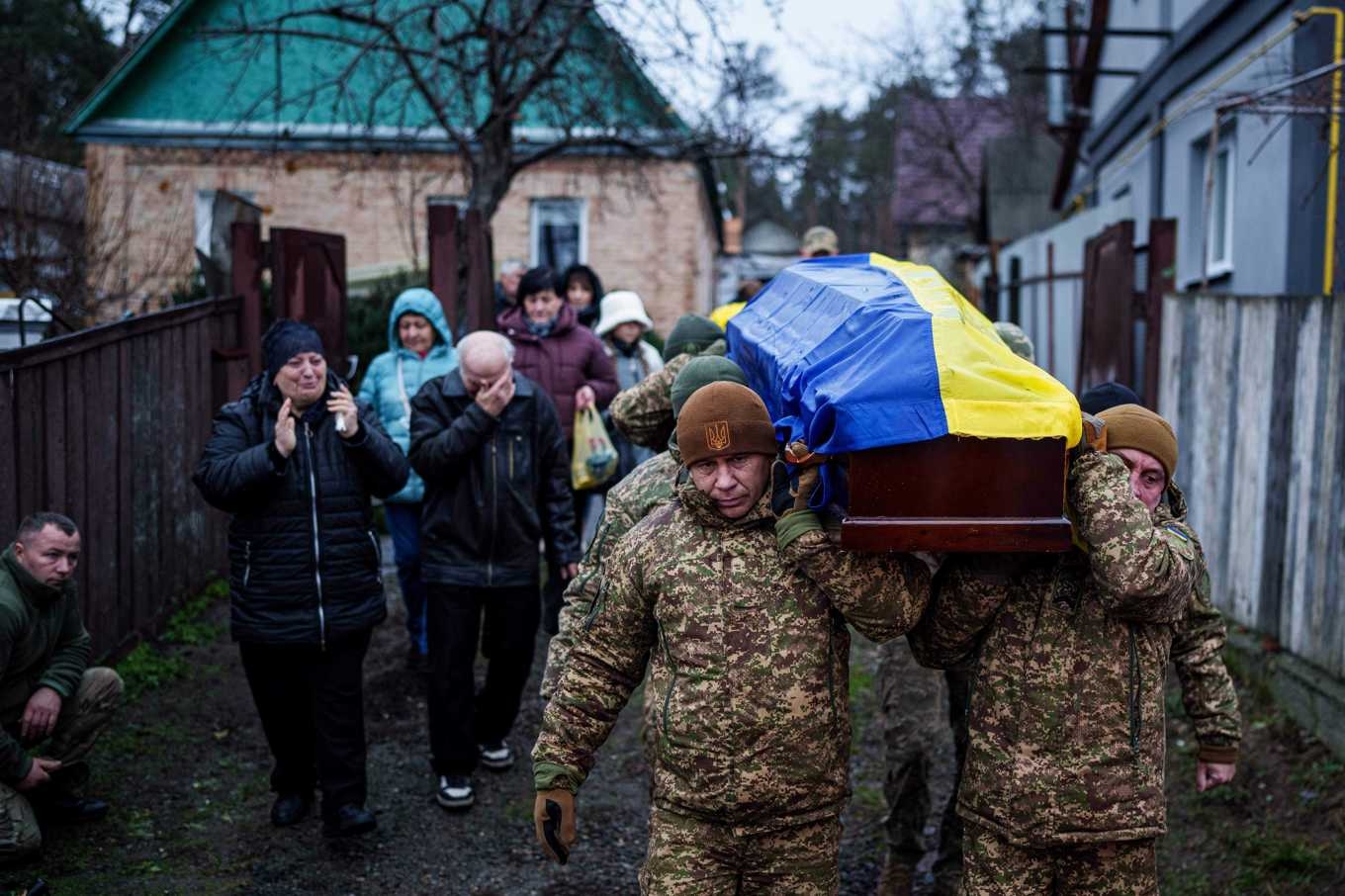 Soldater bär fram kvarlevorna av en kamrat som stupat i kriget, vid en begravningsceremoni i Hostomel den 22 november. Foto: Evgeniy Maloletka/AP/TT