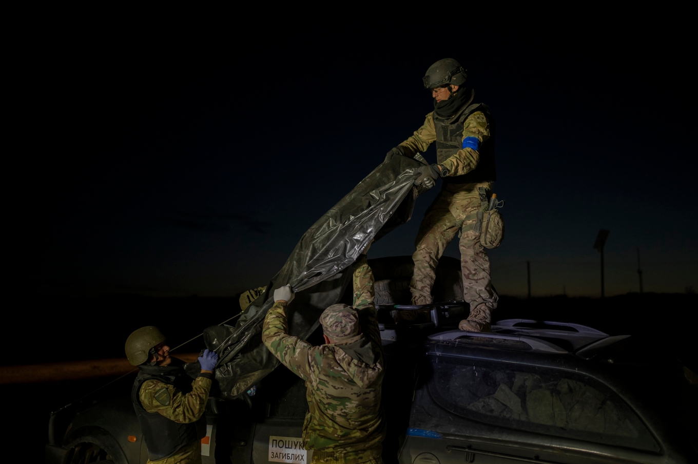 Ukrainska soldater lastar av kvarlevor efter stupade ryska soldater i ukrainska Slovjansk i oktober 2023. Foto: Bram Janssen/AP/TT