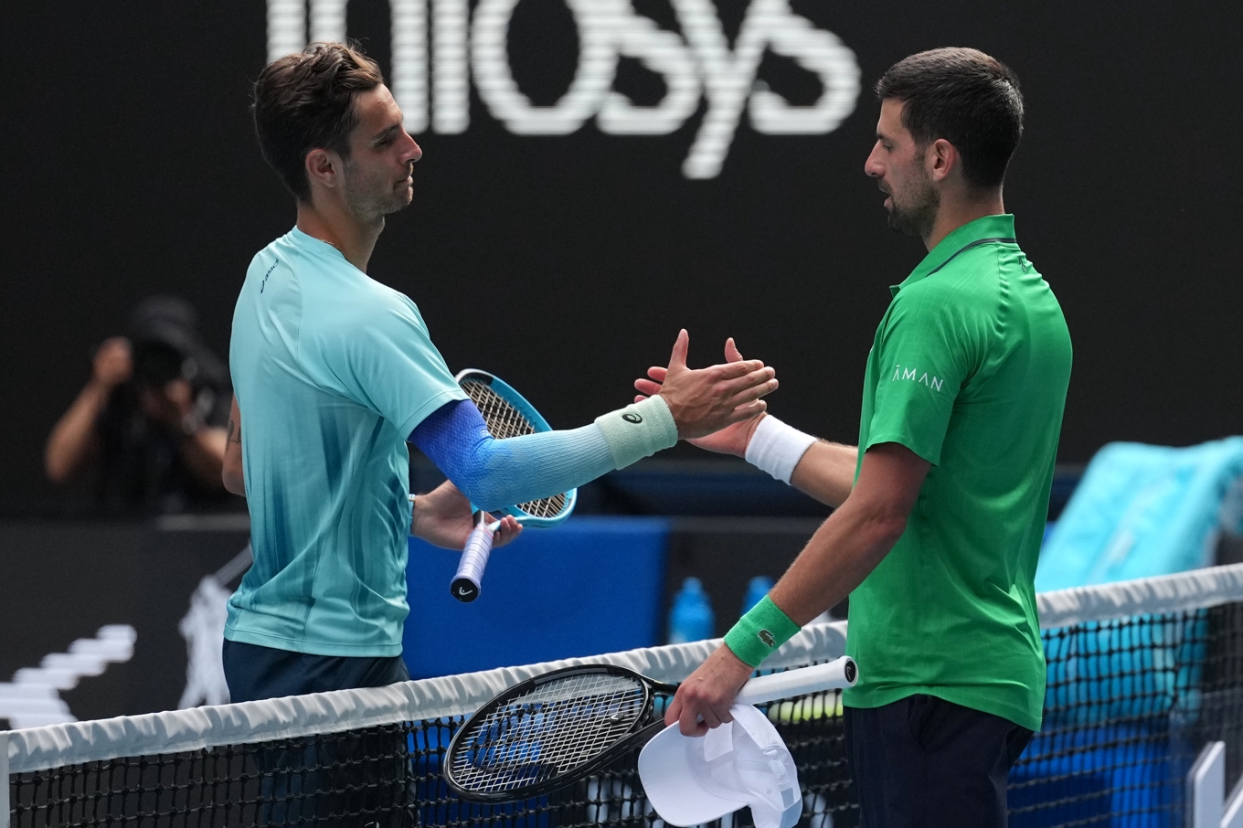 Lorenzo Musetti (till vänster) tvingades ge upp kvartsfinalen i Australian Open mot legendaren Novak Djokovic på grund av skada. Foto: Dita Alangkara /AP/TT