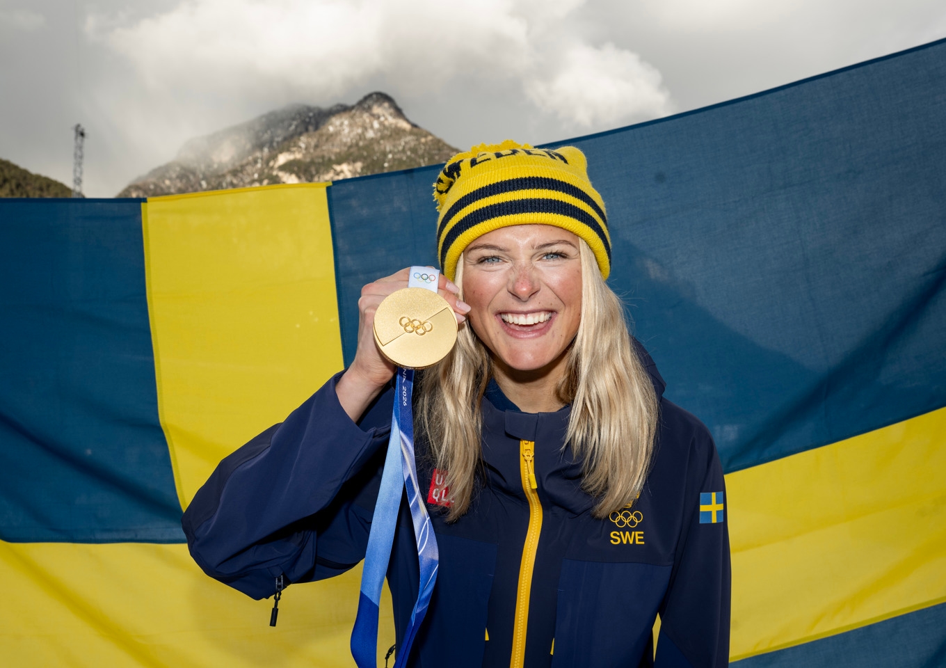 Sveriges Frida Karlsson med sin OS-guldmedalj från damernas skiathlon i Val di Fiemme, som hon vann med 51 sekunders marginal ner till tvåan Ebba Andersson. Foto: Christine Olsson/TT