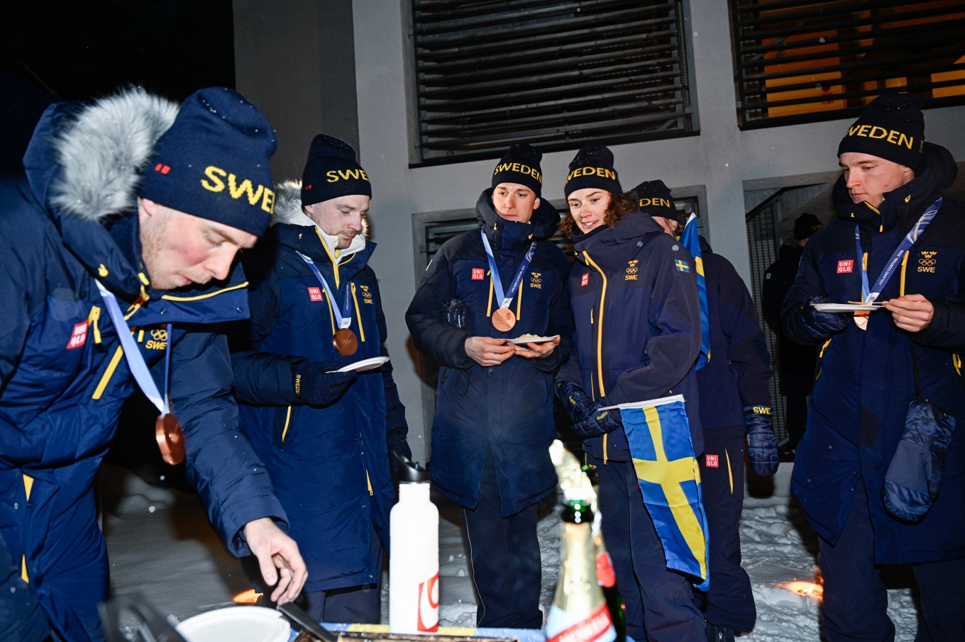 Viktor Brandt, Jesper Nelin, Martin Ponsiluoma, Hanna Öberg och Sebastian Samuelsson firar med tårta efter herrarnas brons i skidskyttestafetten i OS. Foto: Pontus Lundahl/TT