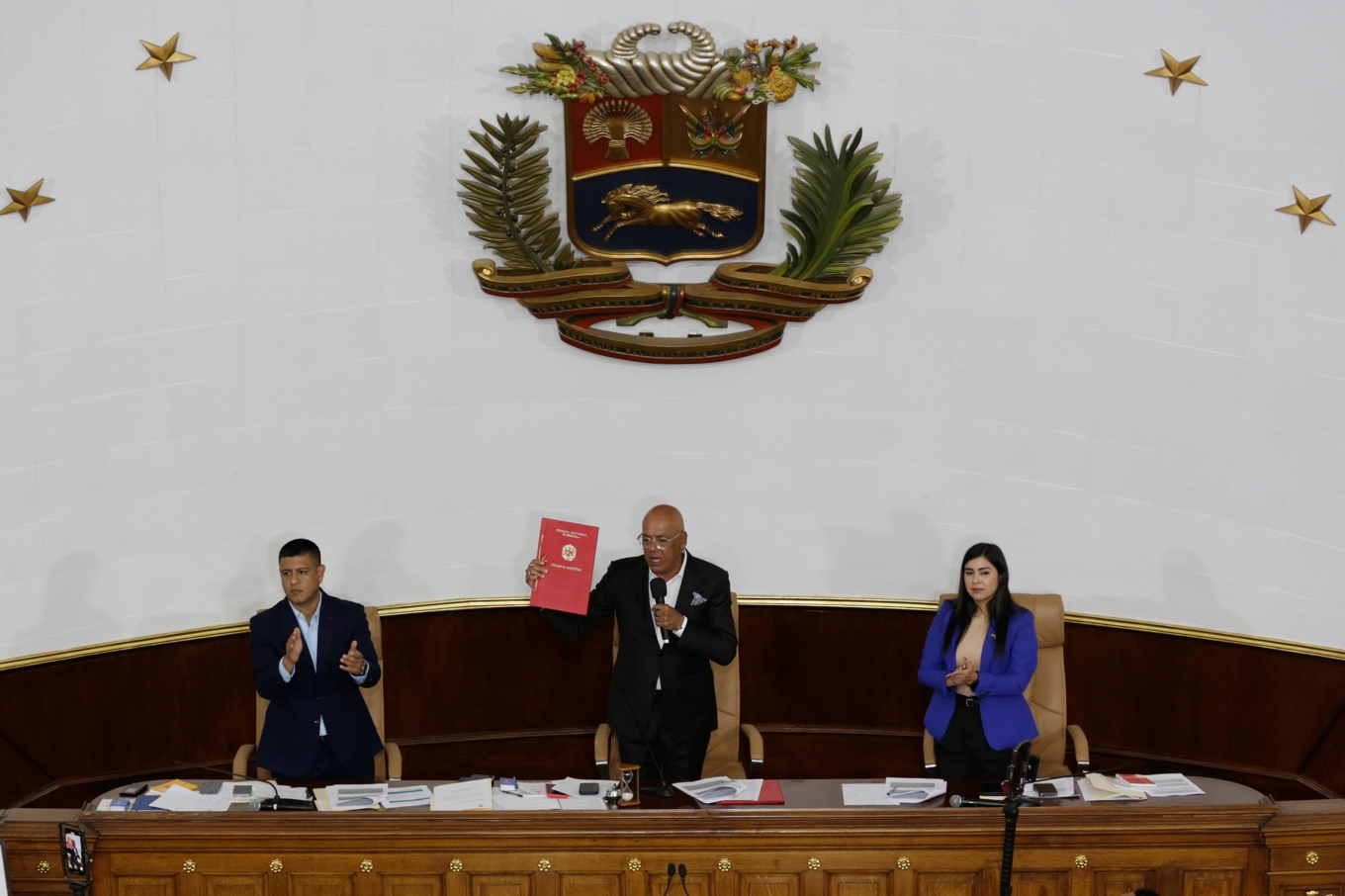 Jorge Rodríguez (mitten) talman i Venezuelas nationalförsamling håller upp den nya lagtexten. Foto: Crisitian Hernandez/AP/TT