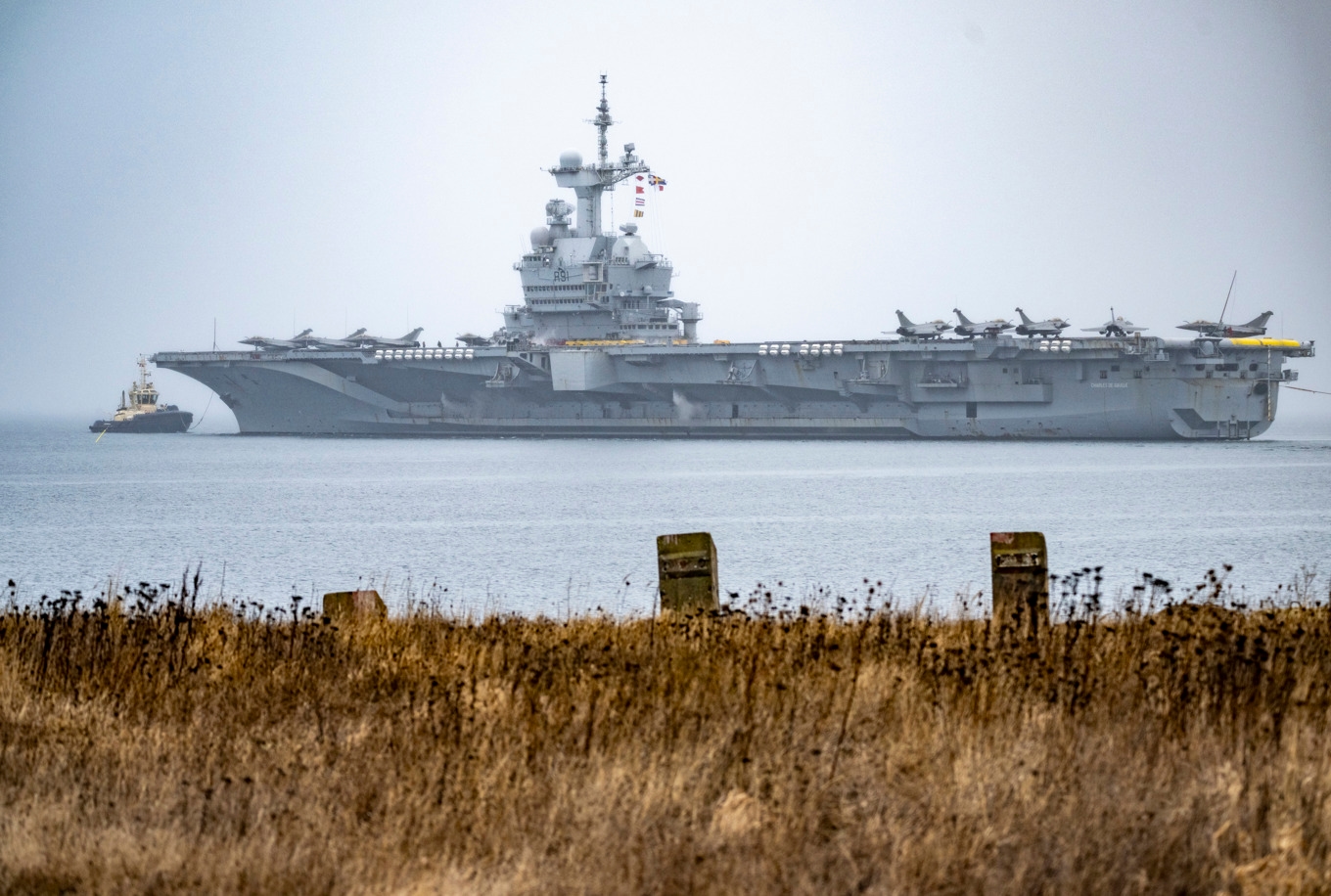 Assisterad av bogserbåtar lämnar det franska hangarfartyget Charles De Gaulle (R91) kaj i Norra hamnen i Malmö. Foto: Johan Nilsson / TT