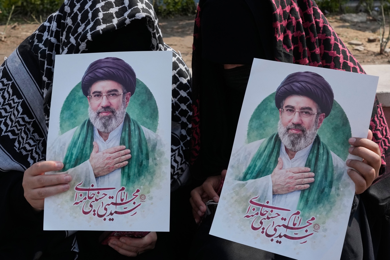 Två kvinnor i Teheran håller upp bilder på den nye ledaren Mojtaba Khamenei. Foto: Vahid Salemi /AP/TT